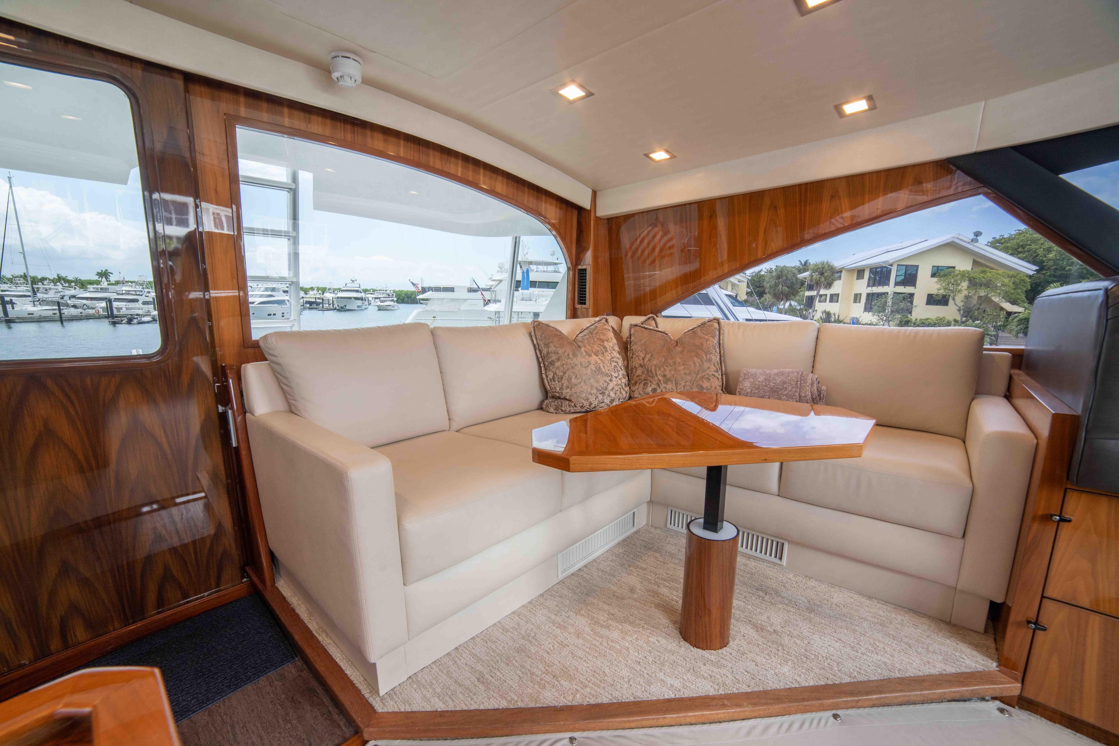 Luxurious interior of 2019 Viking 72 Enclosed Bridge yacht with plush seating and elegant wood finishes.