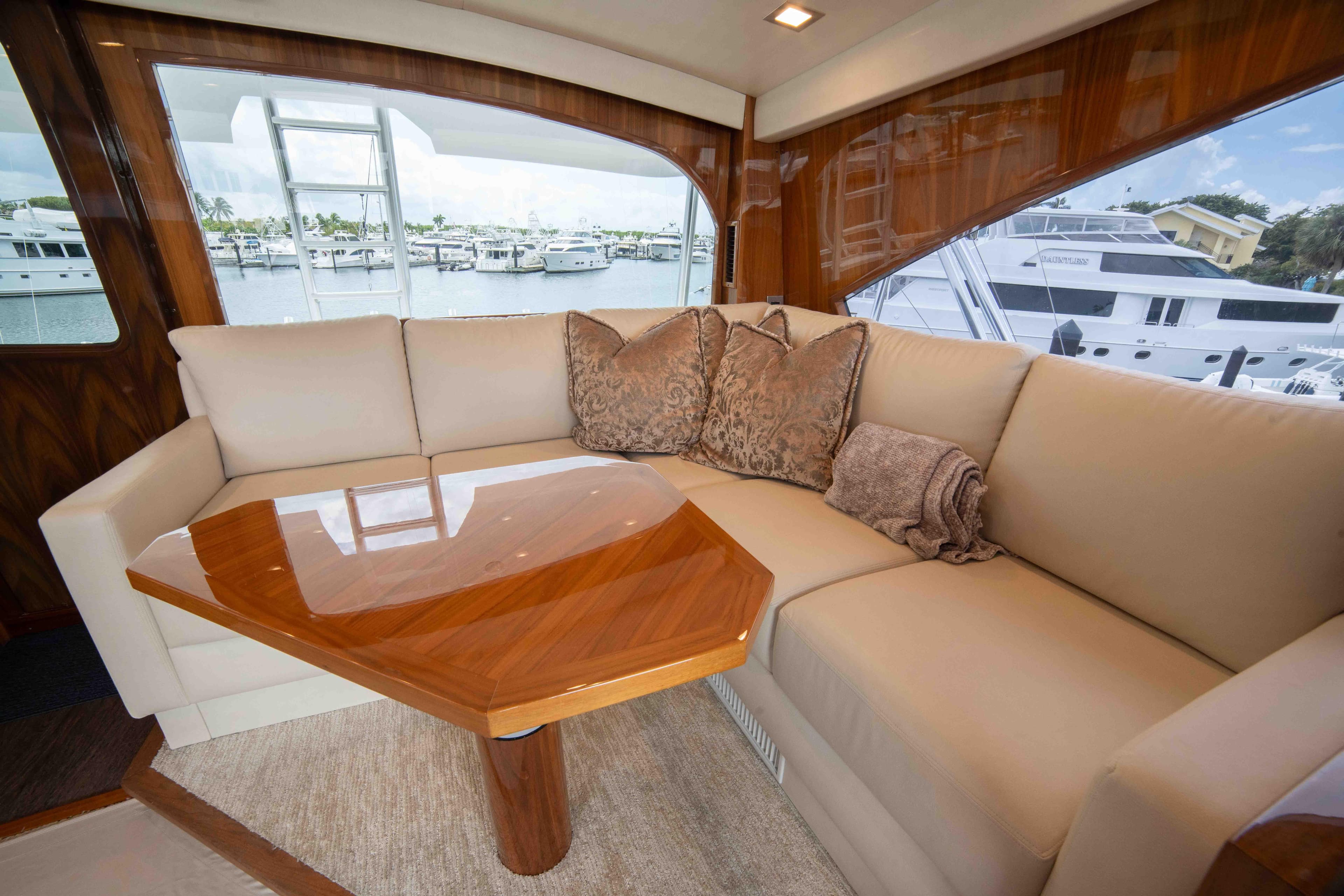 Luxurious interior of 2019 Viking 72 Enclosed Bridge yacht with plush seating and wooden table.