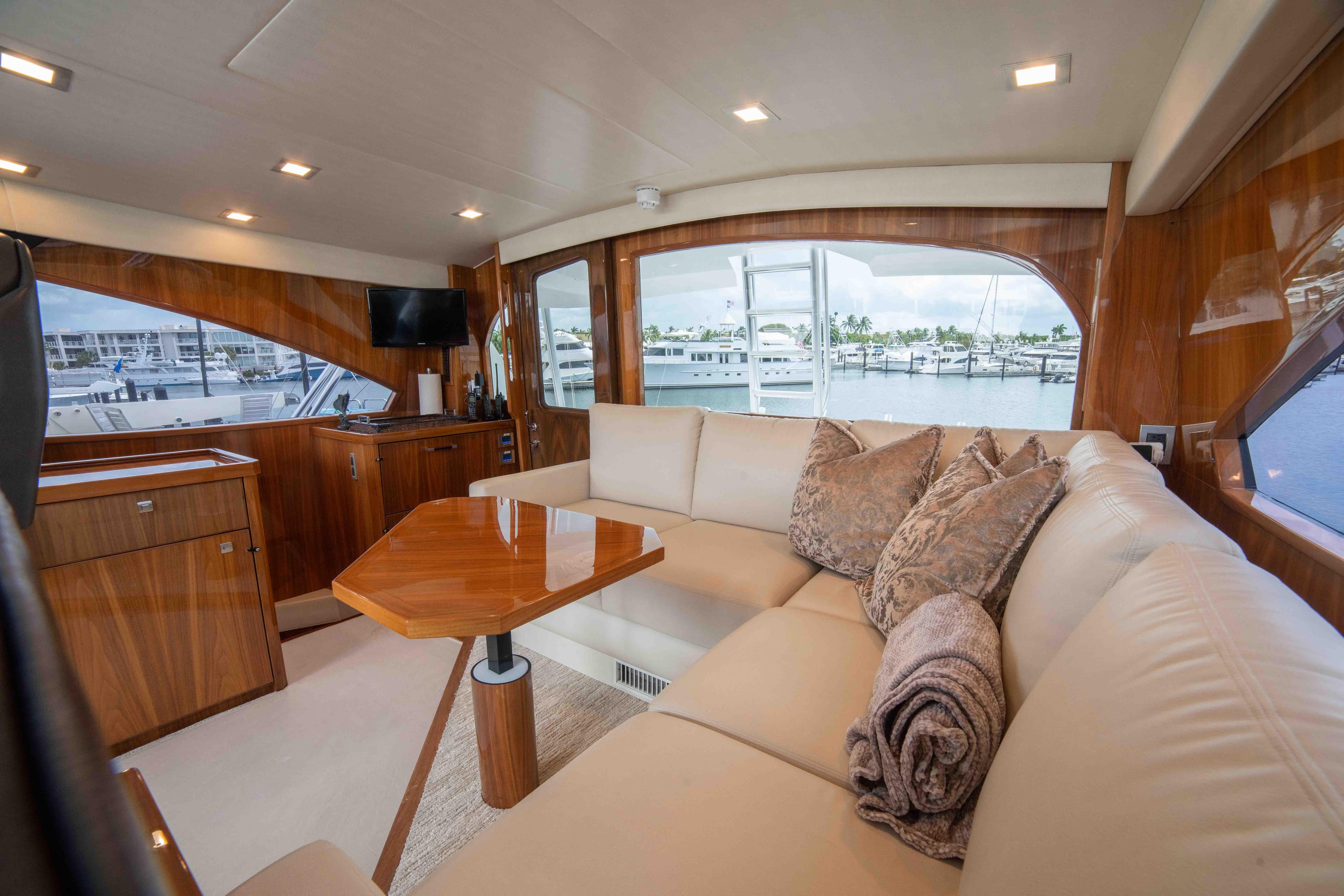 Luxurious interior of 2019 Viking 72 Enclosed Bridge yacht with plush seating and elegant wood finishes.