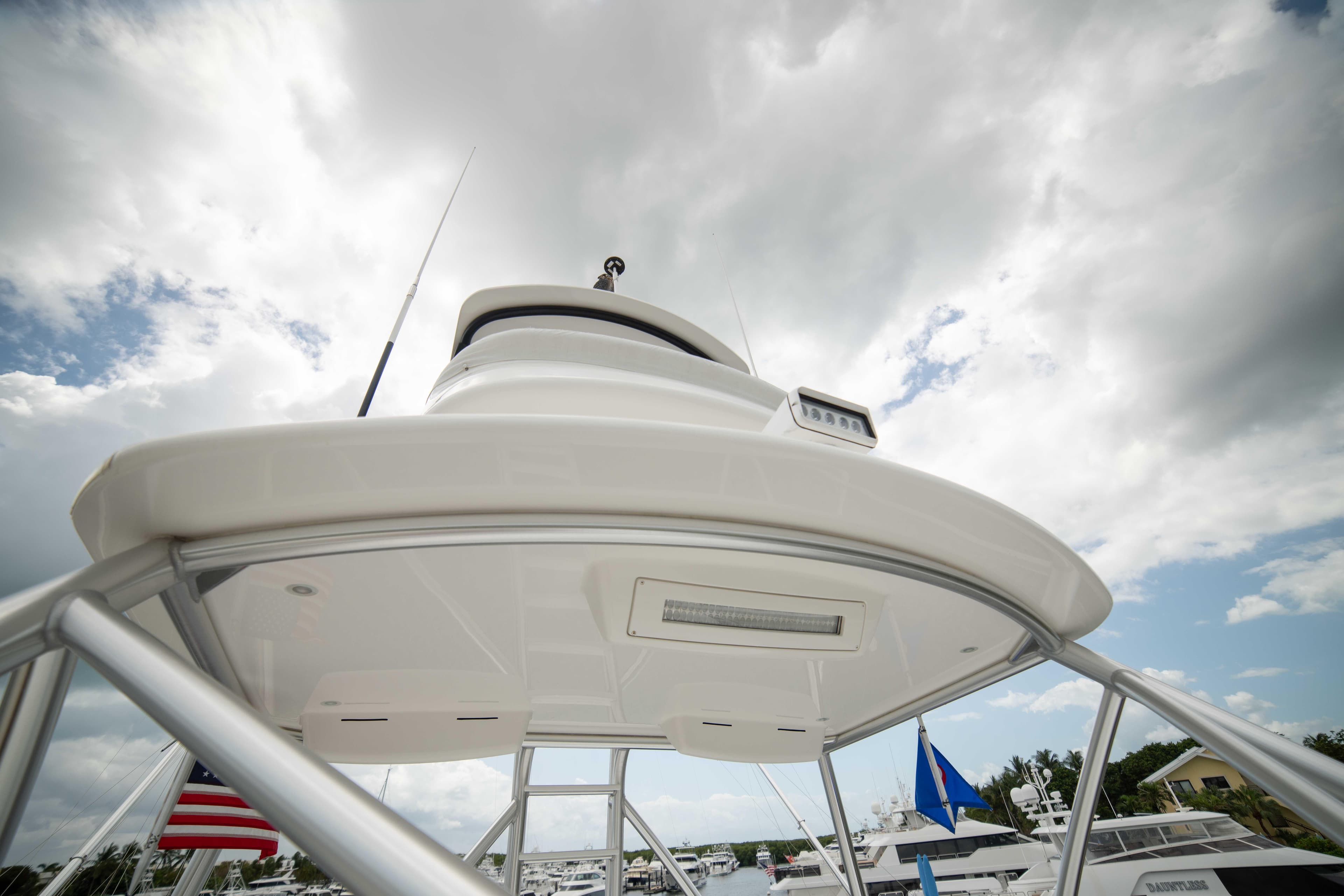 2019 Viking 72 Enclosed Bridge yacht, view of upper deck and radar, cloudy sky background.