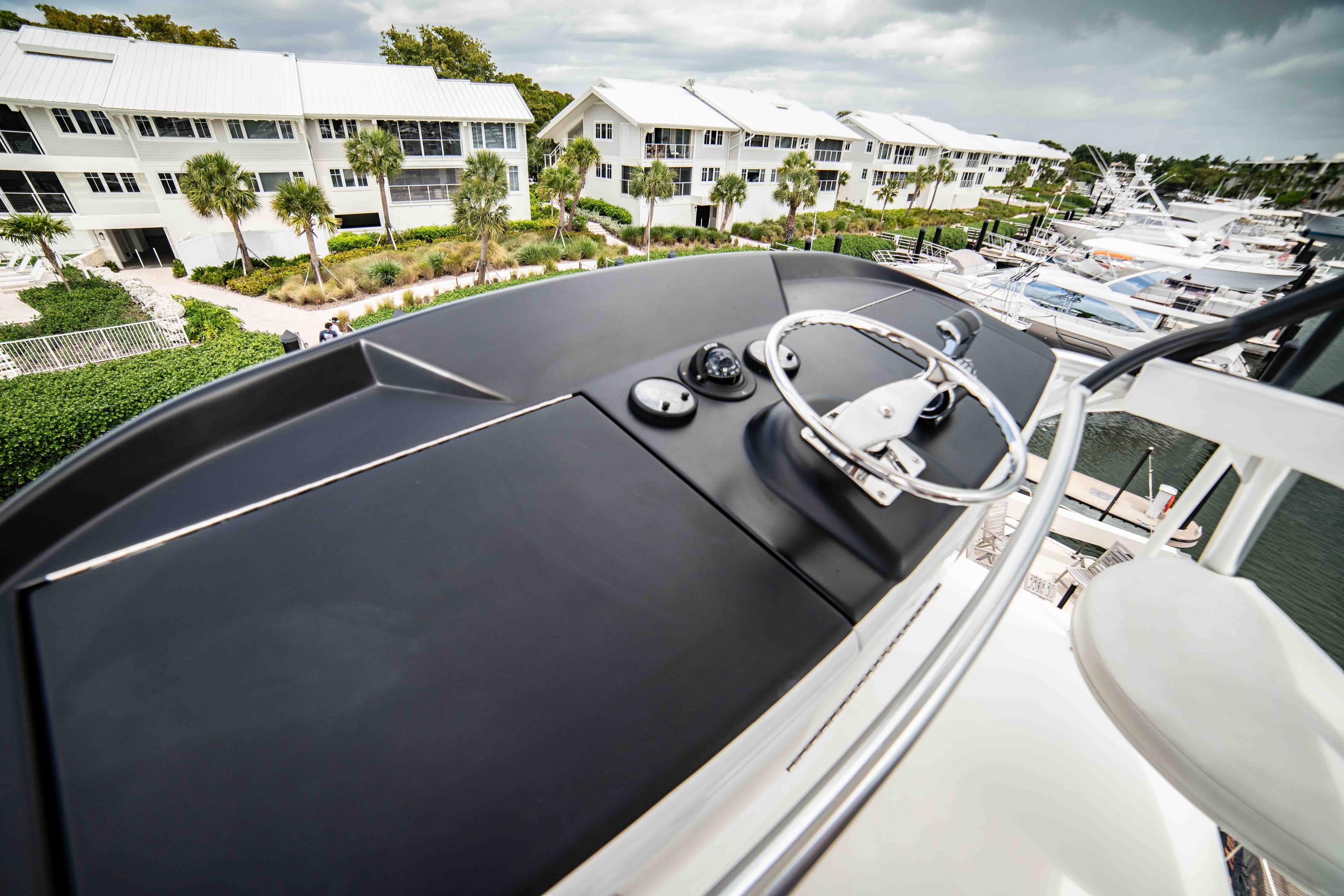 2019 Viking 72 Enclosed Bridge yacht helm with marina and waterfront view.