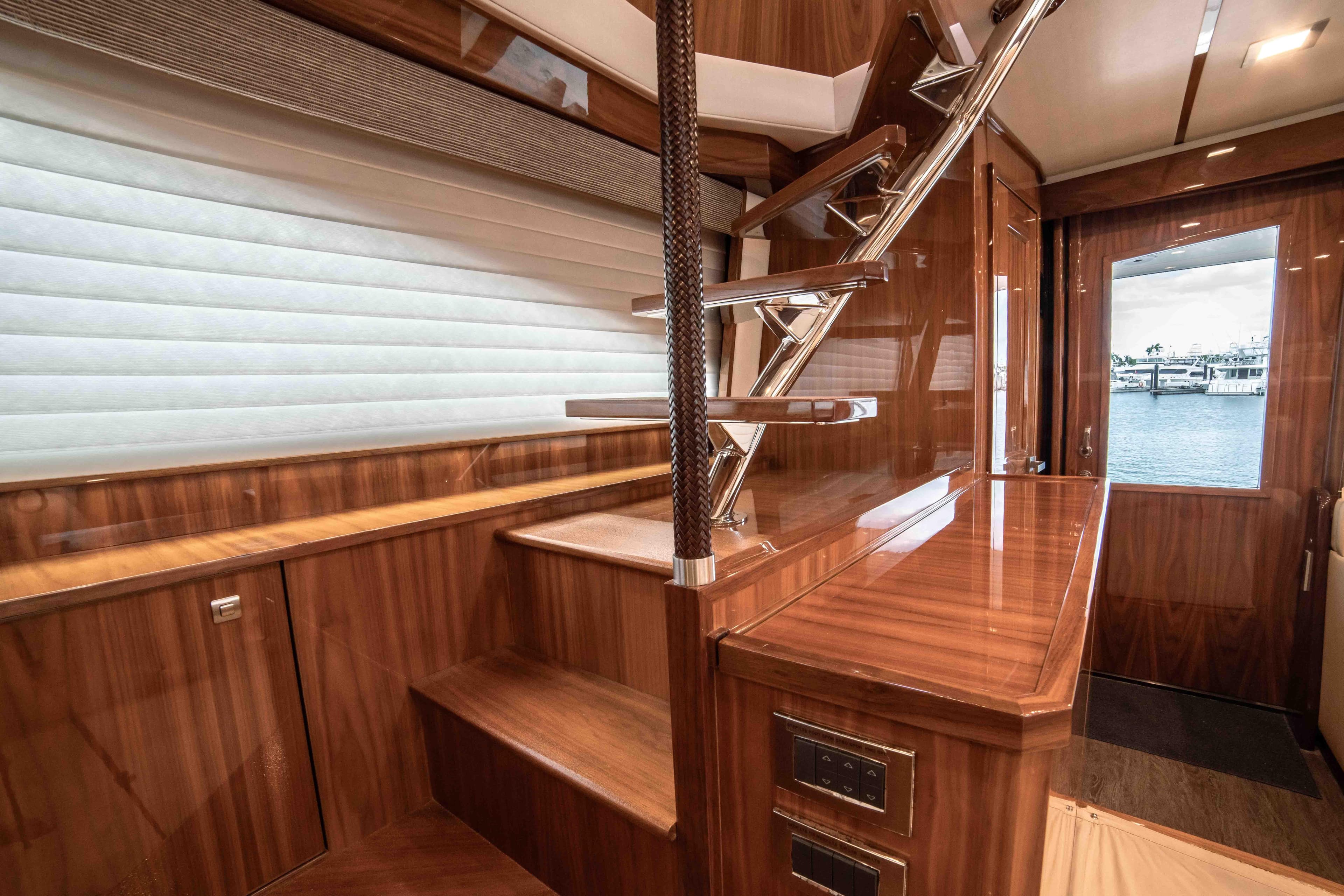 Interior of 2019 Viking 72 Enclosed Bridge yacht with wooden stairs and elegant design.