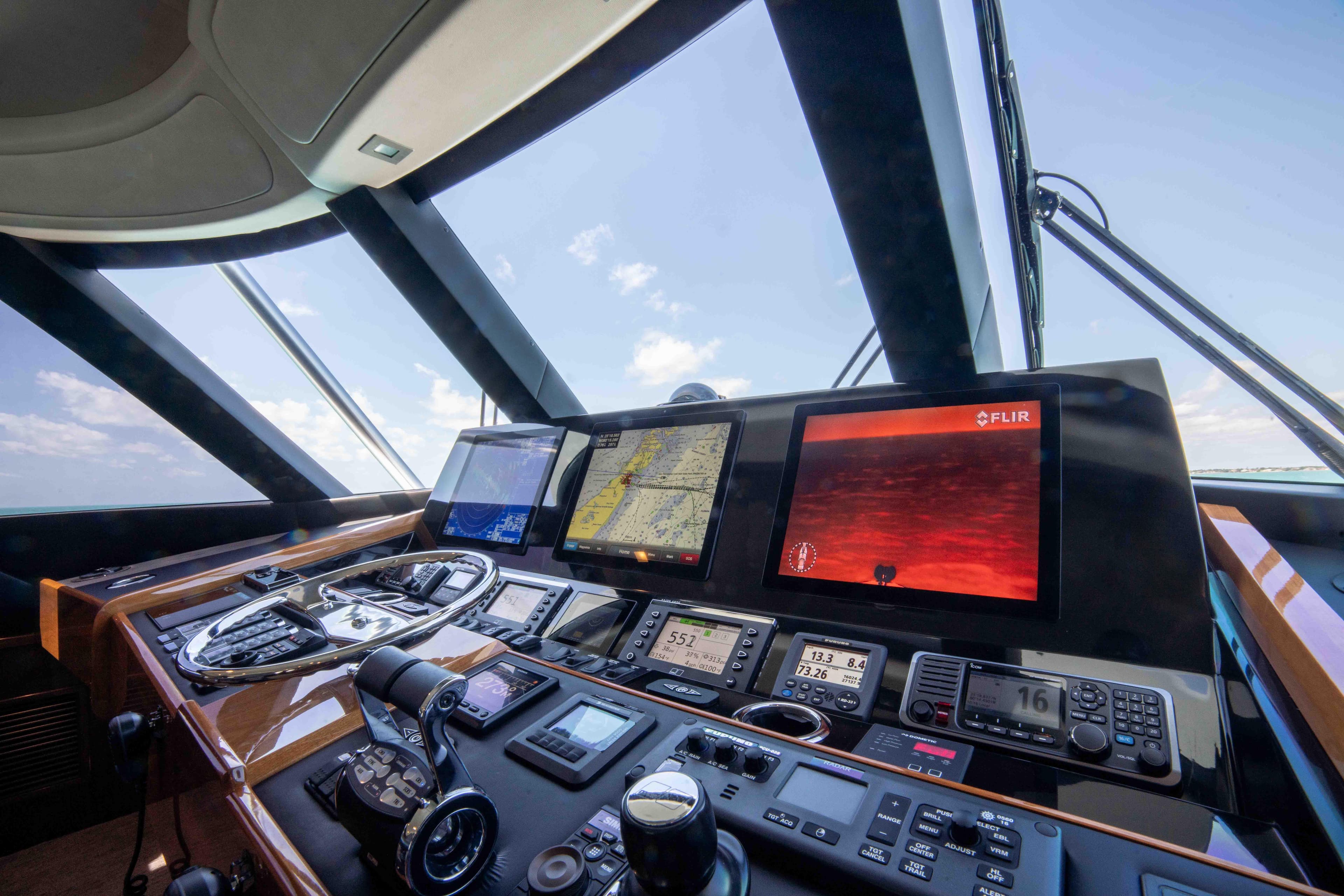 Control panel of 2019 Viking 72 Enclosed Bridge yacht with navigation screens.