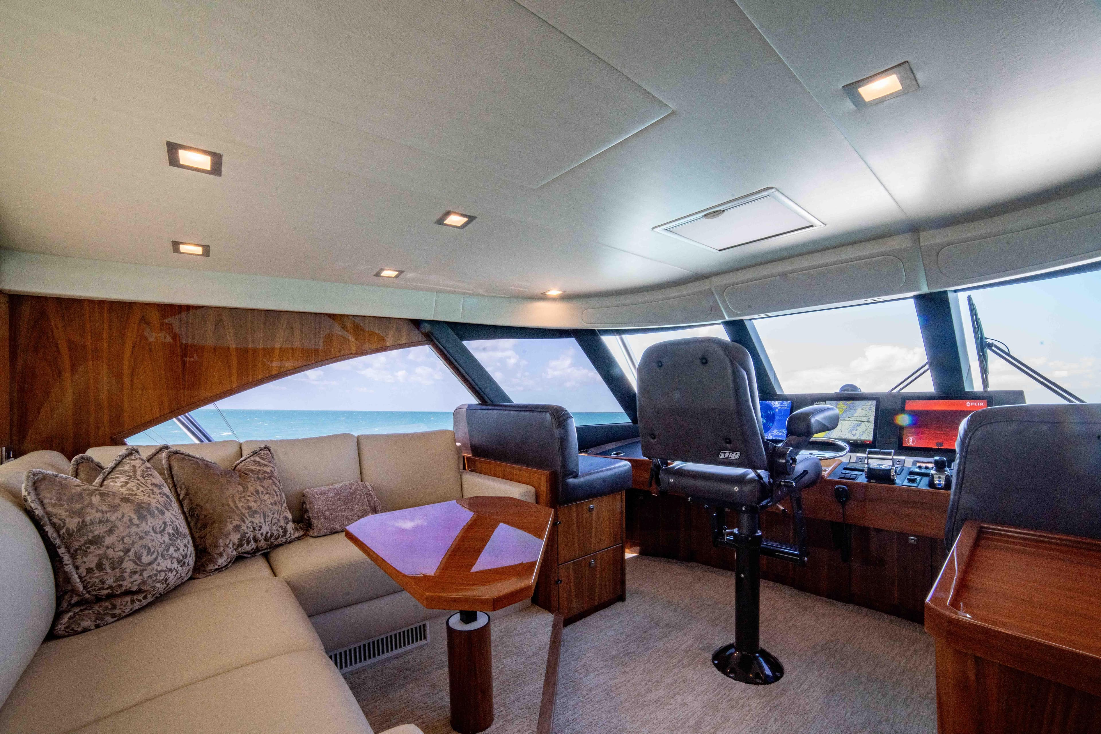 Luxurious interior of 2019 Viking 72 Enclosed Bridge yacht with plush seating and modern helm.