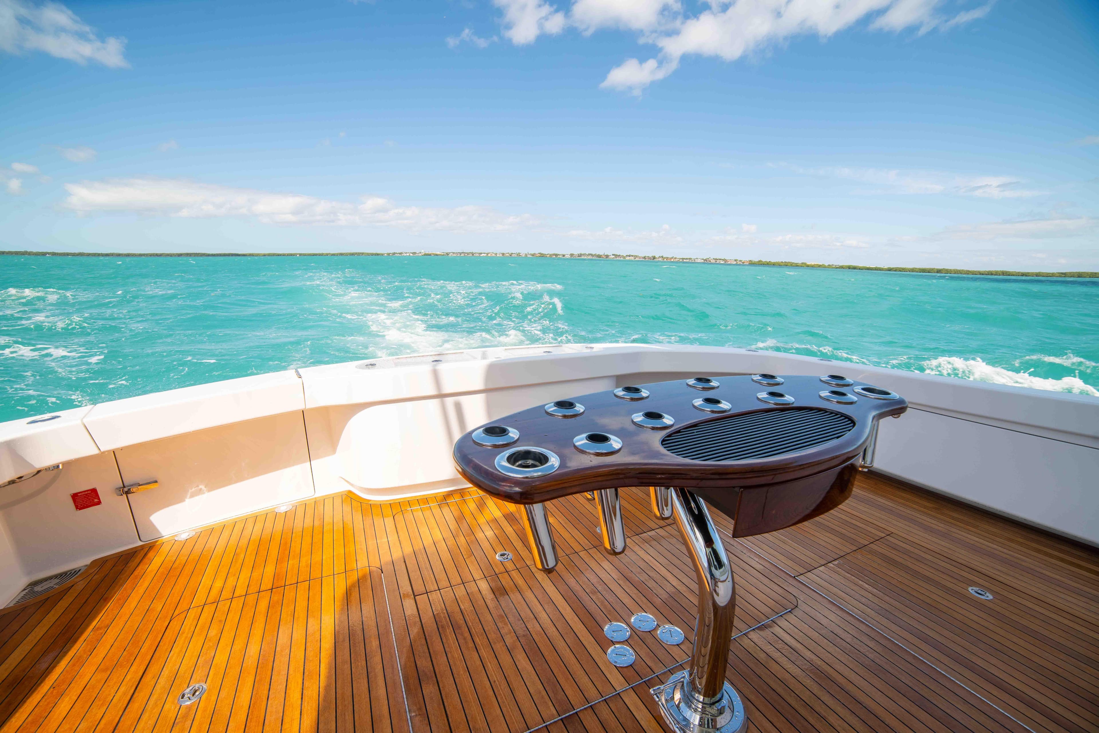 2019 Viking 72 Enclosed Bridge yacht deck with ocean view and fishing rod holders.