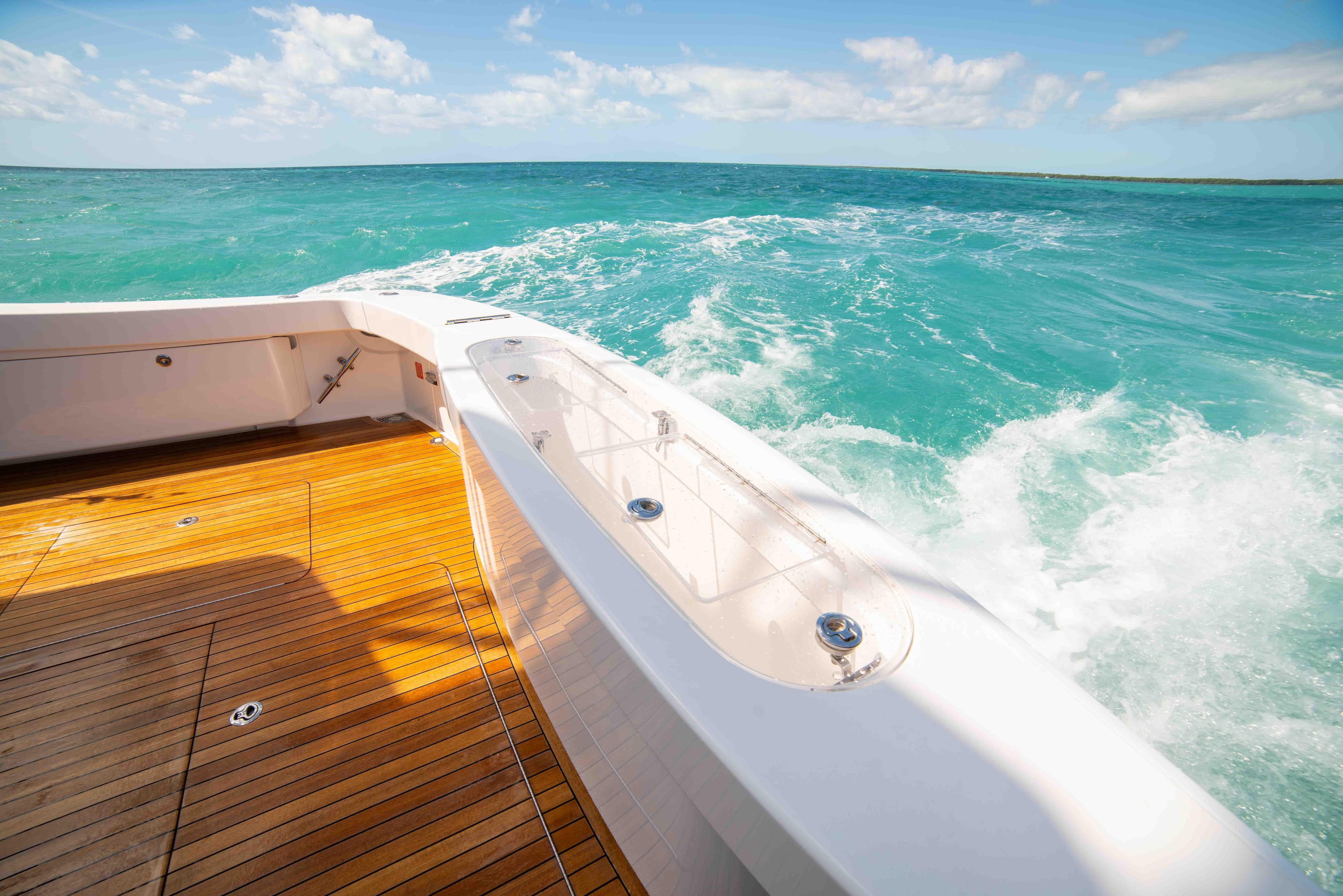 2019 Viking 72 Enclosed Bridge yacht cruising on turquoise waters, featuring teak deck.