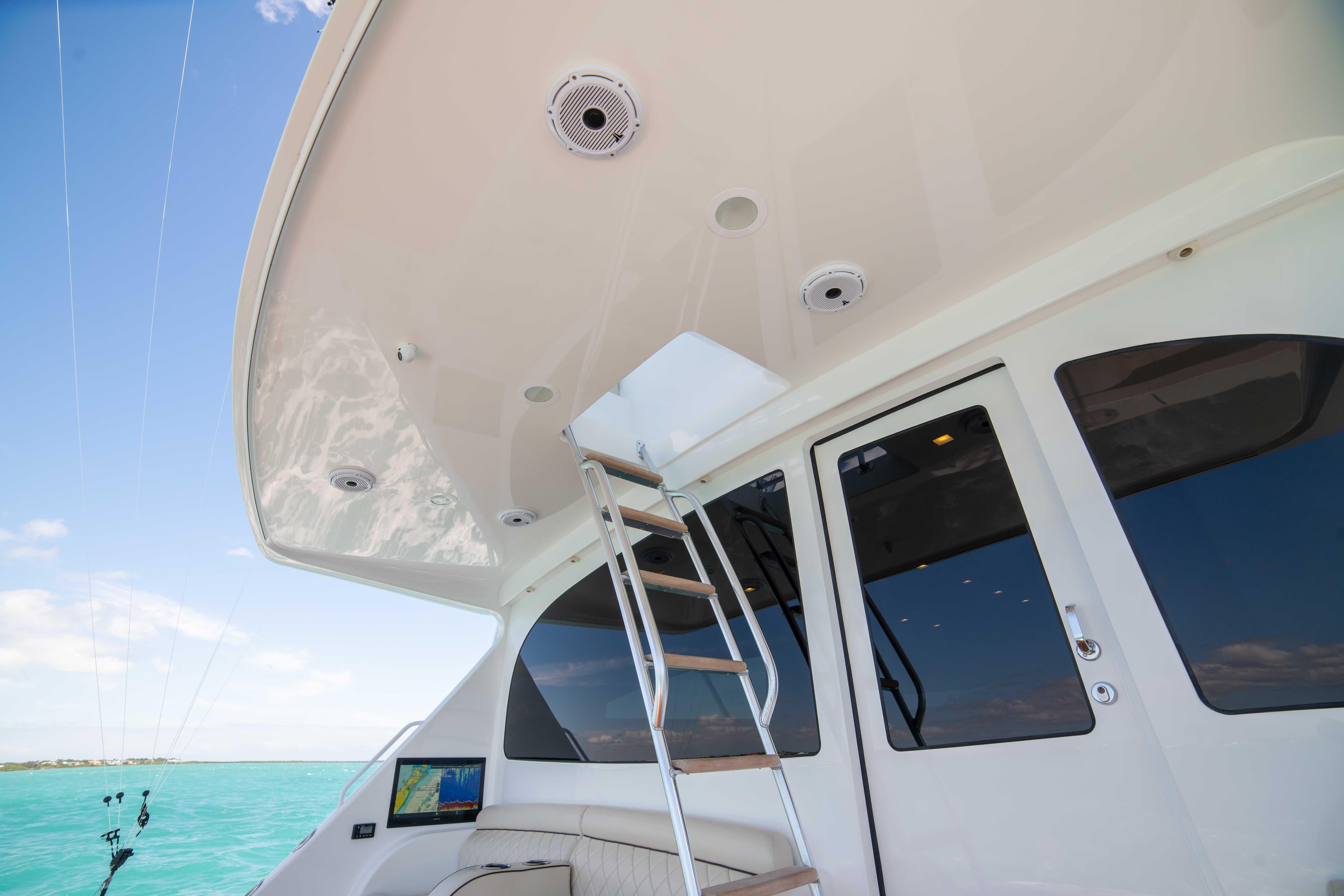 2019 Viking 72 Enclosed Bridge yacht with ladder and ocean view.