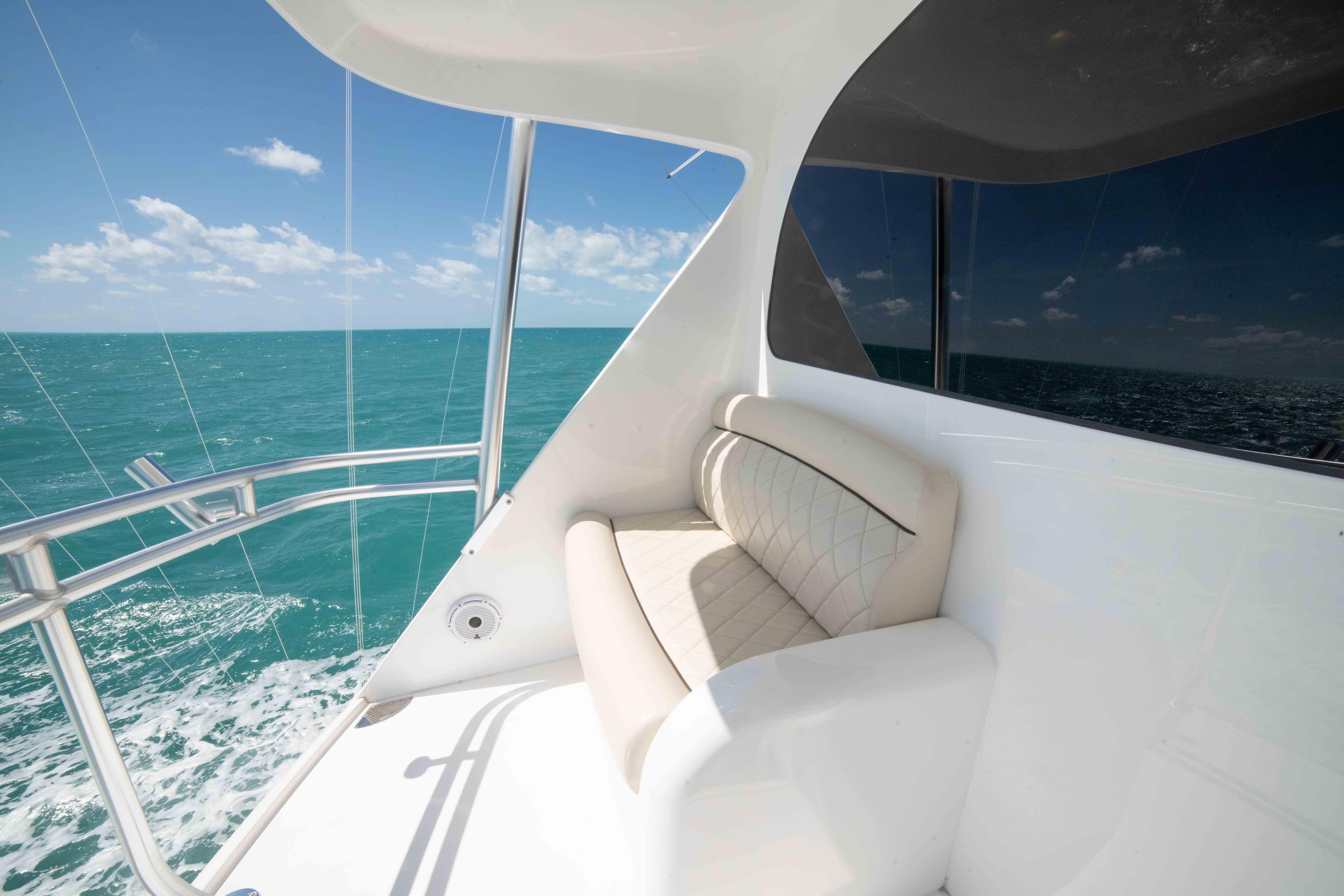 2019 Viking 72 Enclosed Bridge yacht with ocean view and comfortable seating.
