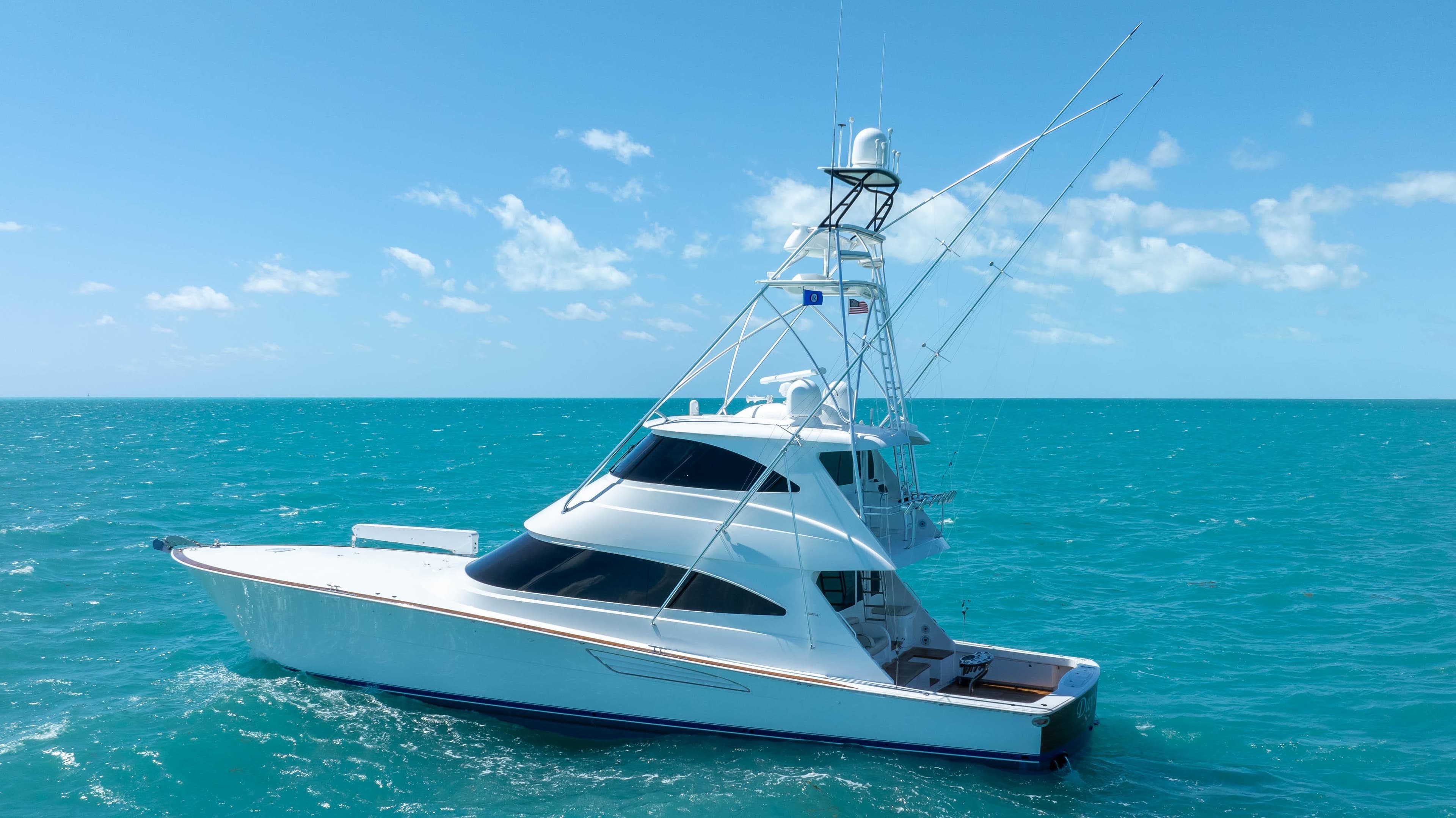 2019 Viking 72 Enclosed Bridge yacht on turquoise ocean under clear blue sky.