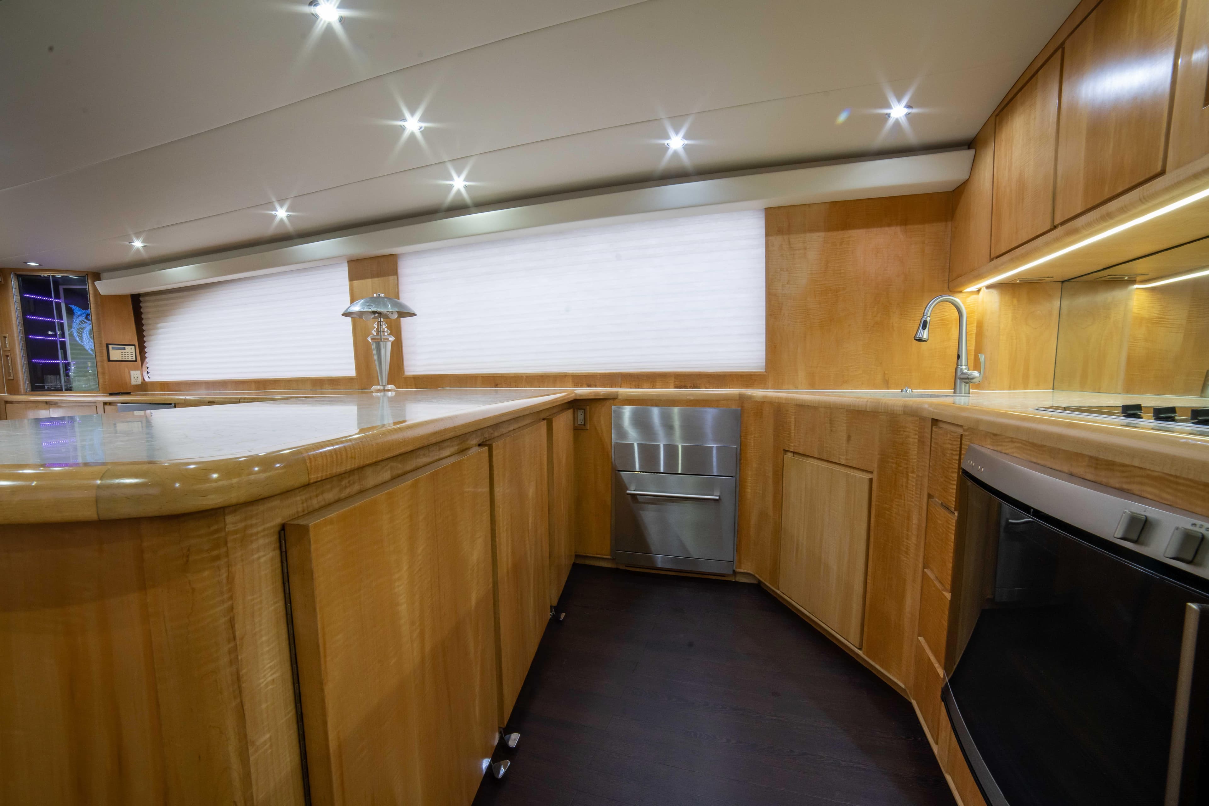 Luxurious kitchen interior of 1996 Donzi 72 Custom Convertible yacht with modern wooden cabinetry.