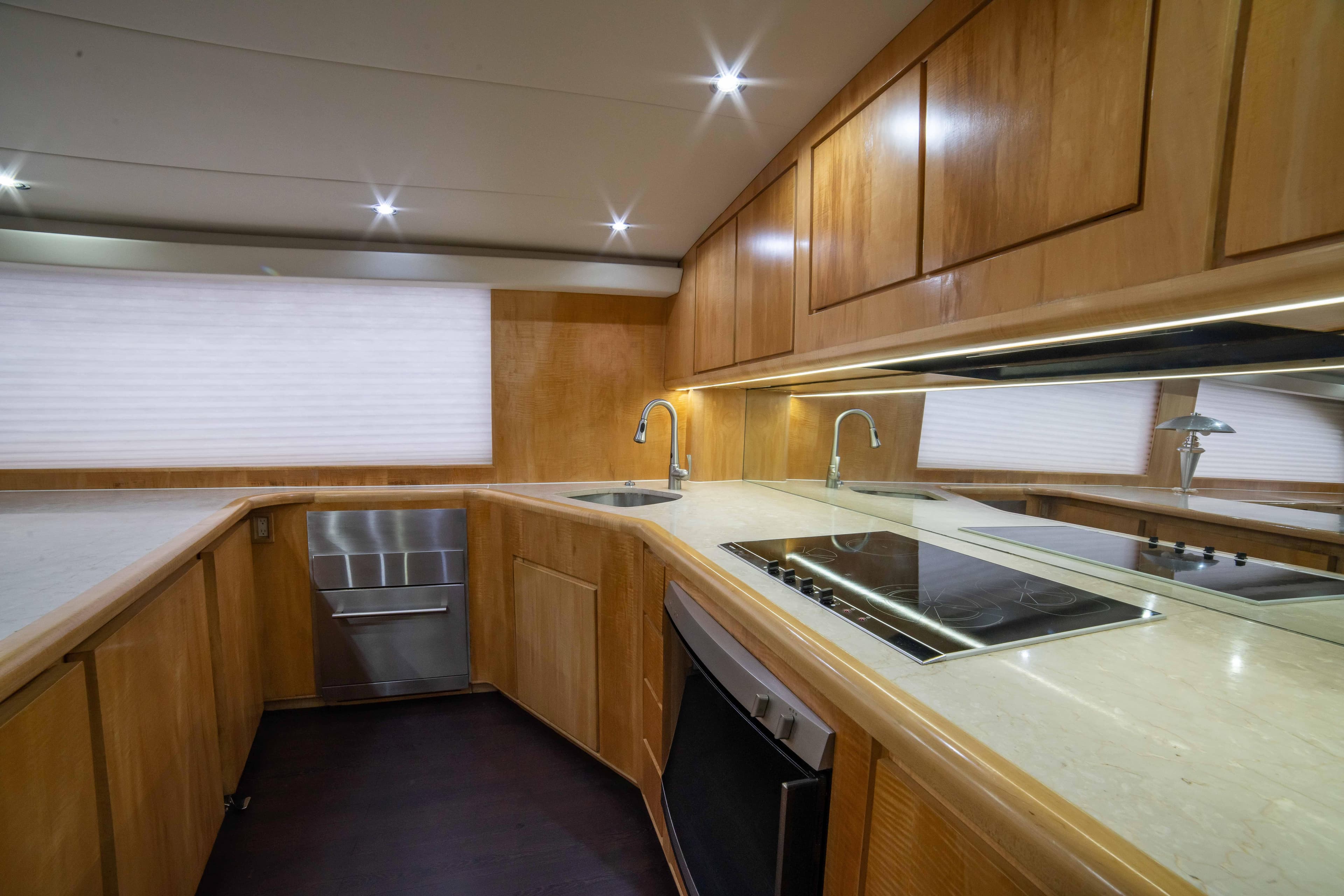Modern kitchen in a 1996 Donzi 72 Custom Convertible yacht with wood cabinetry.