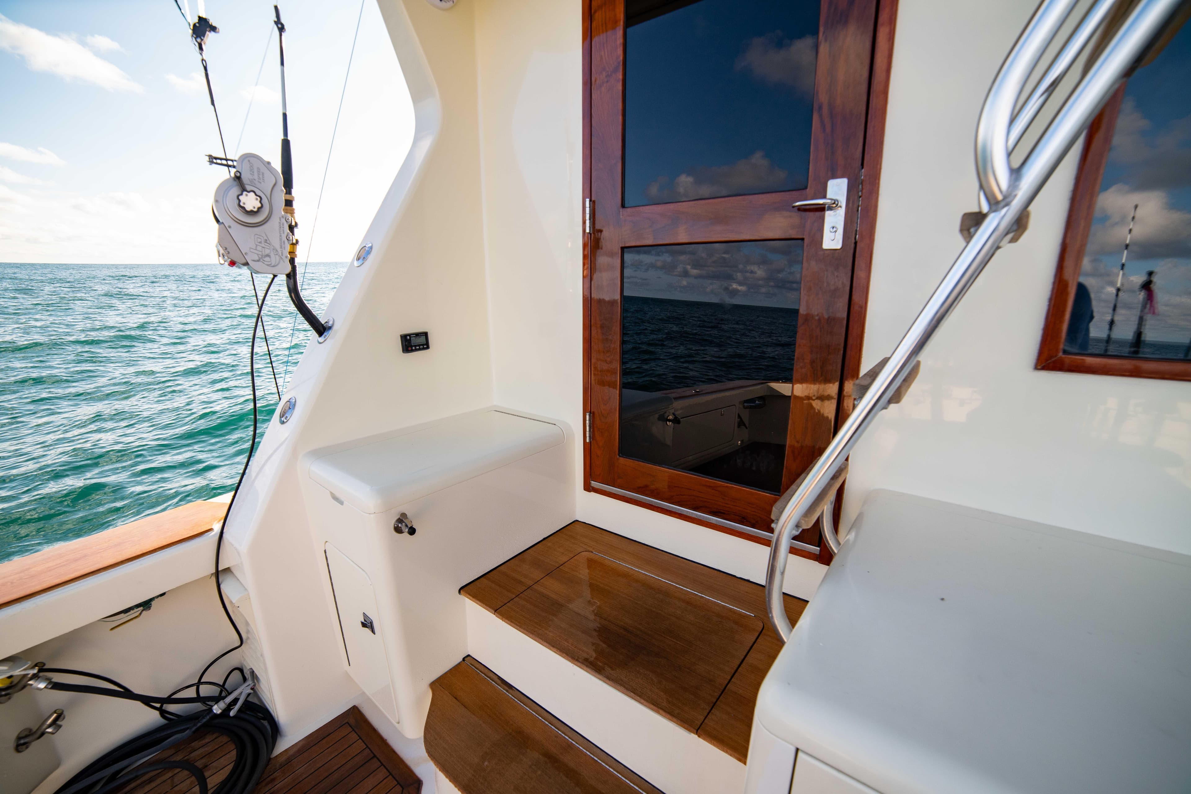 1996 Donzi 72 Custom Convertible boat deck with wooden steps and ocean view.