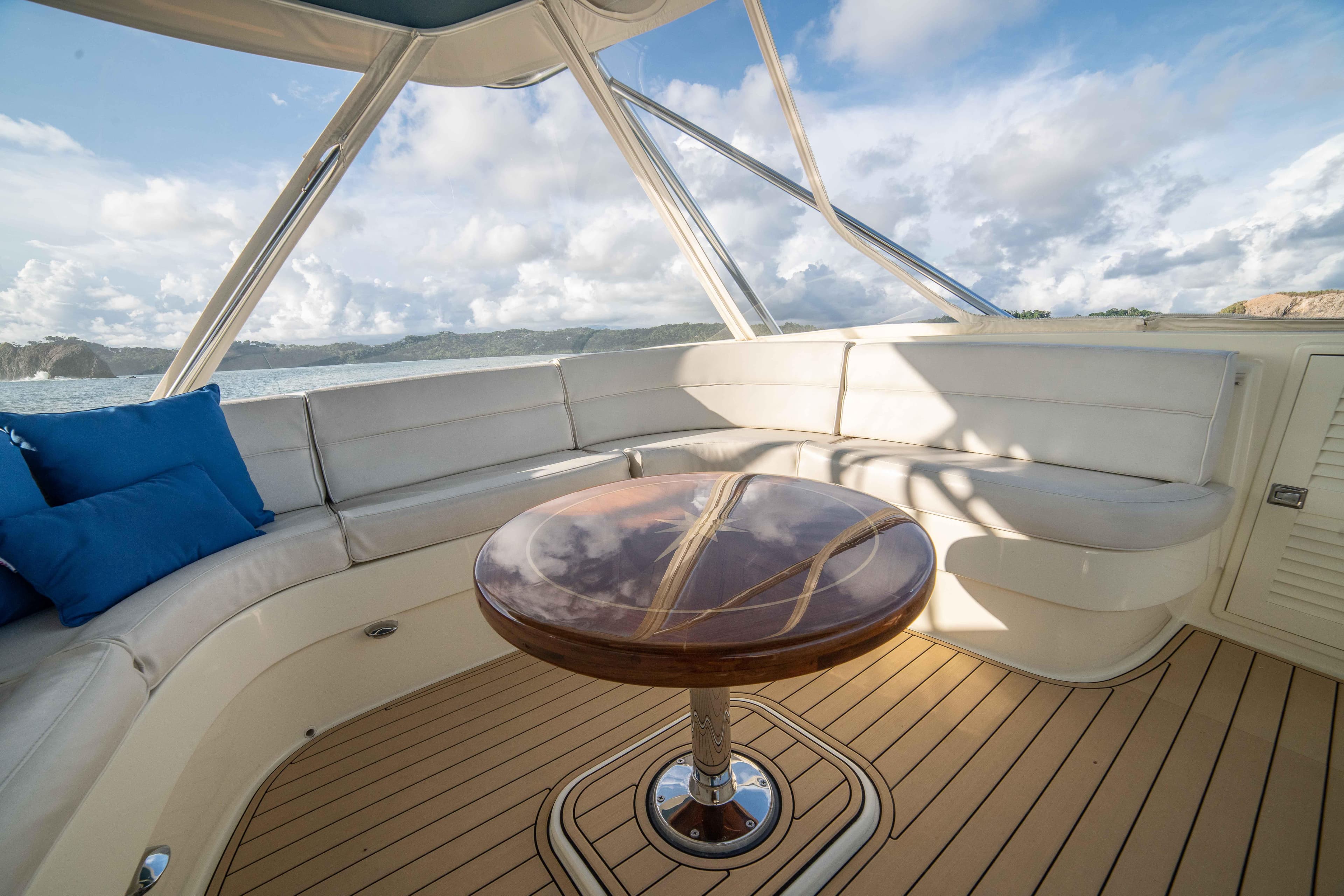 1996 Donzi 72 Custom Convertible yacht interior with white seating and wooden table.