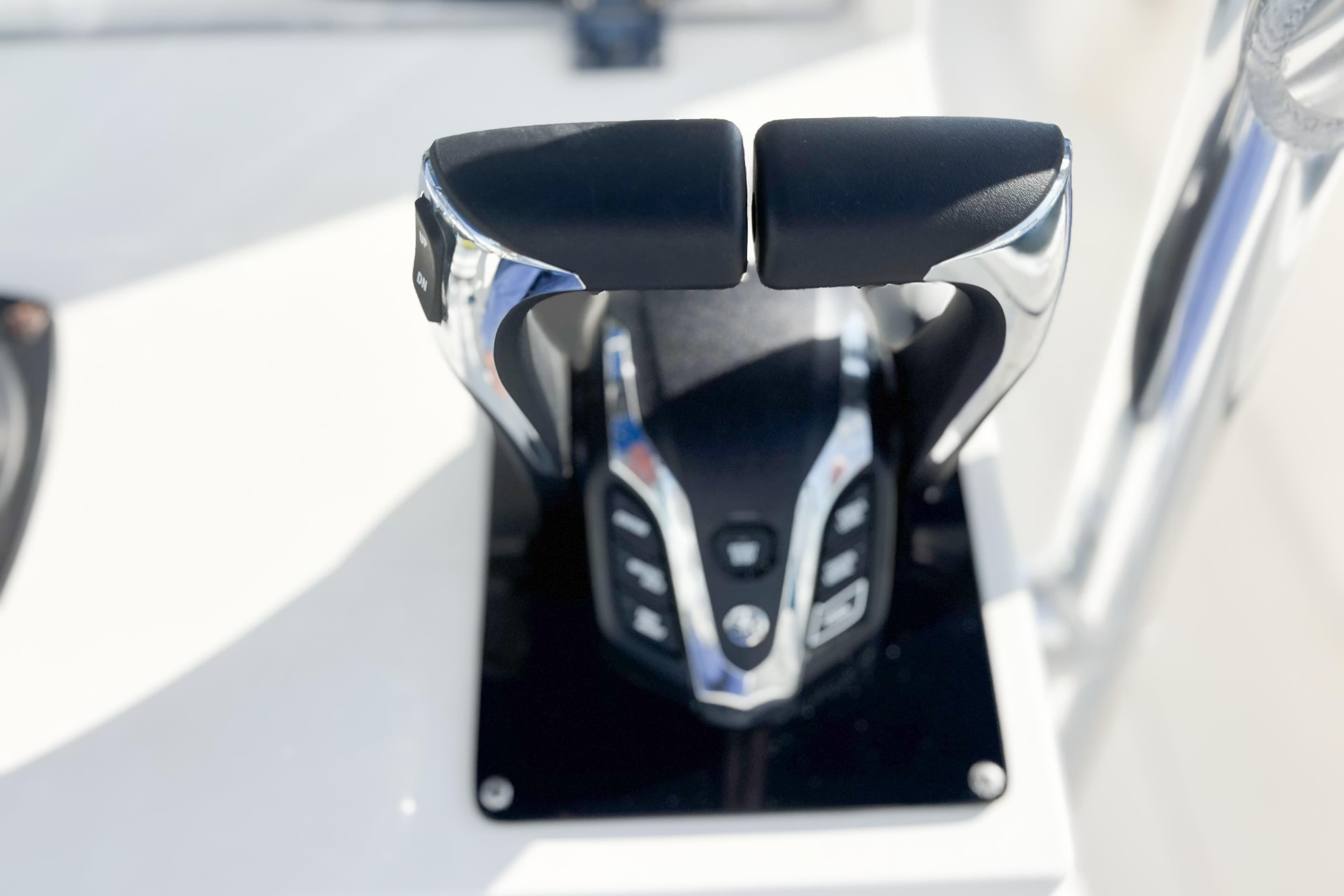 Close-up of a 2016 Whitewater boat throttle control lever on a white surface.