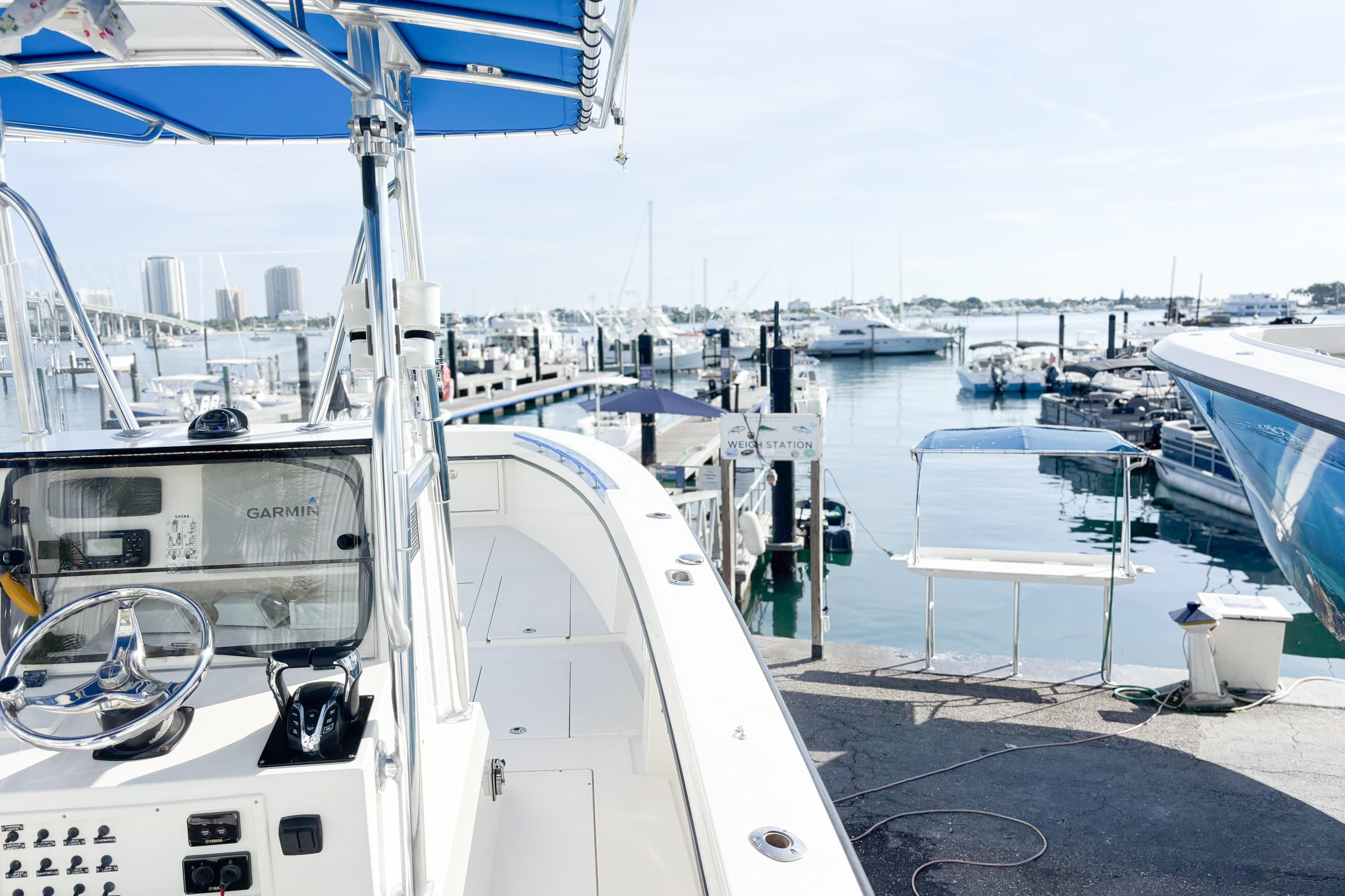 Whitewater boat docked at marina, featuring Garmin navigation, with city skyline in background.