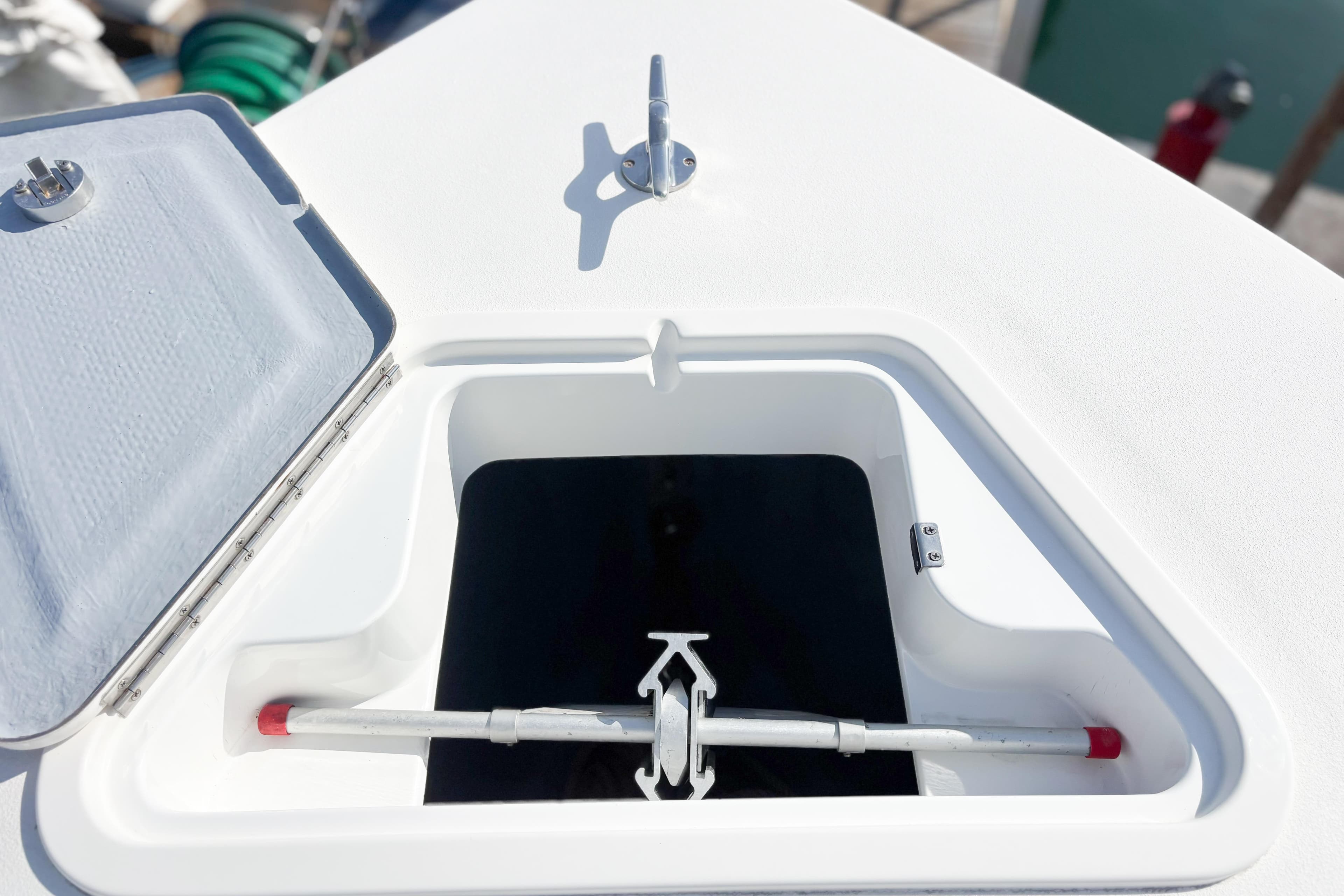 Open hatch on 2016 Whitewater boat deck, revealing storage compartment.
