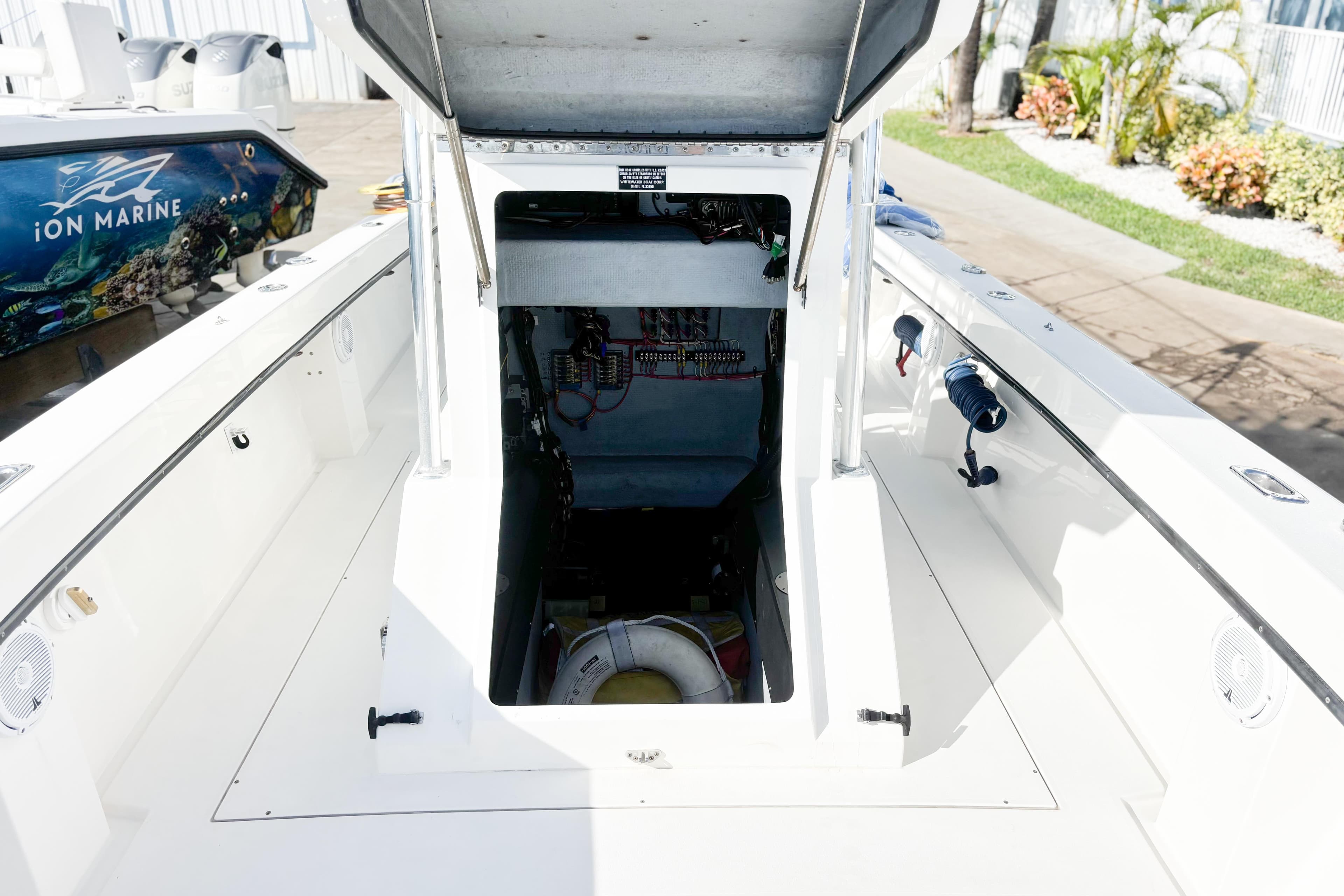 Open hatch on a 2016 Whitewater boat, revealing interior wiring and equipment.