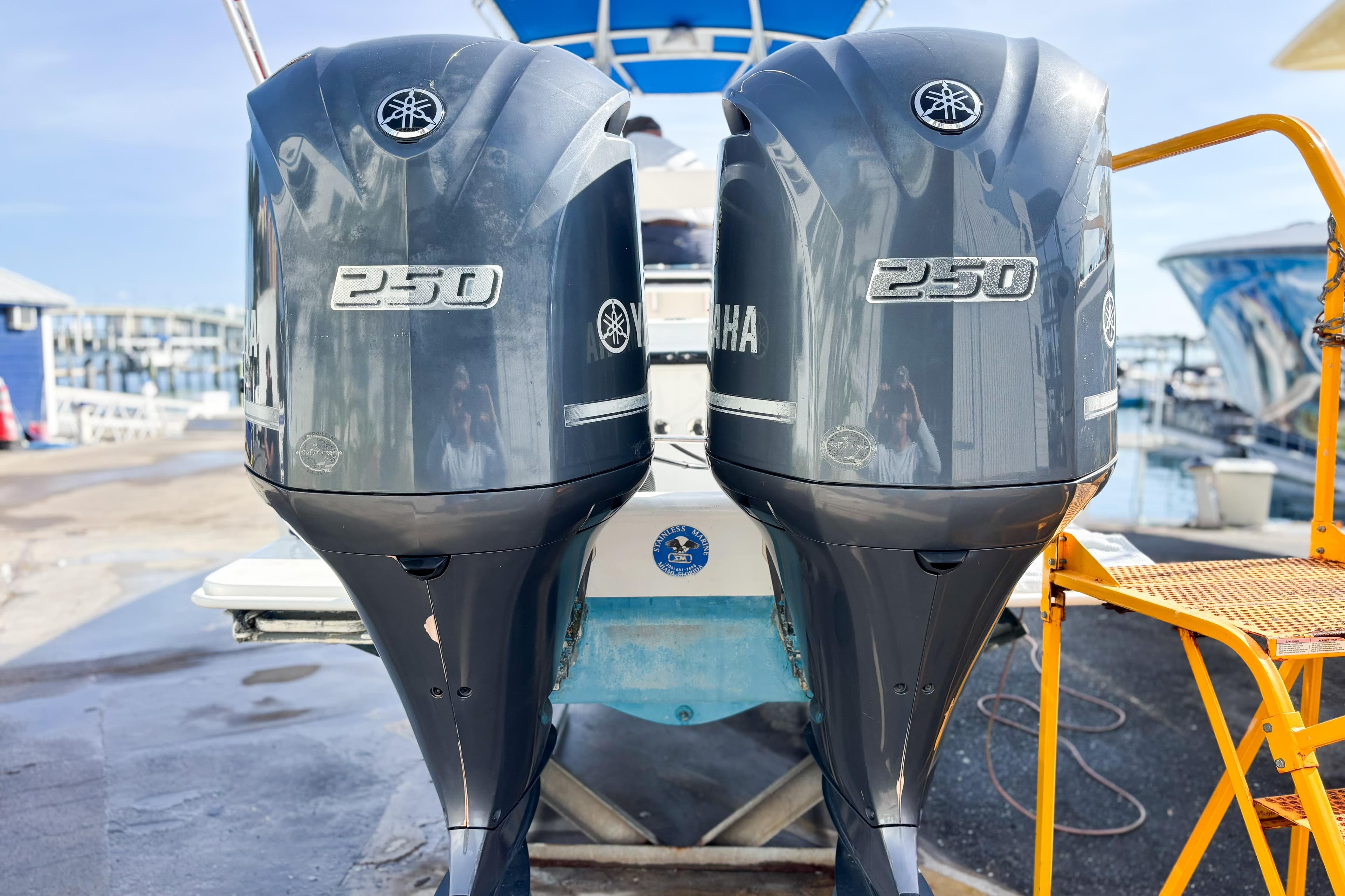 Twin Yamaha 250 outboard motors on a 2016 Whitewater boat at a marina.