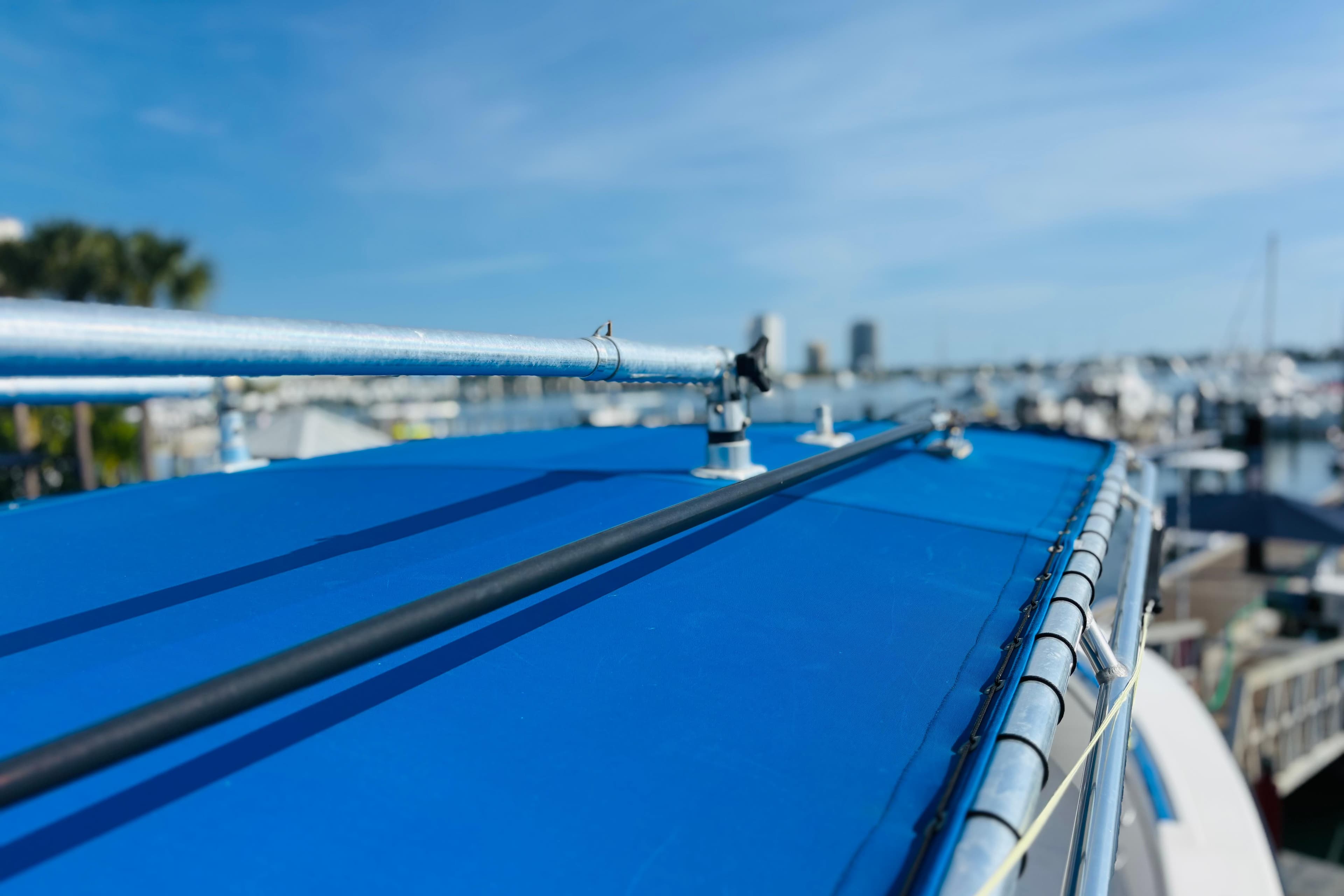 Blue boat roof with railing, docked at marina, clear sky background. Whitewater, 2016.