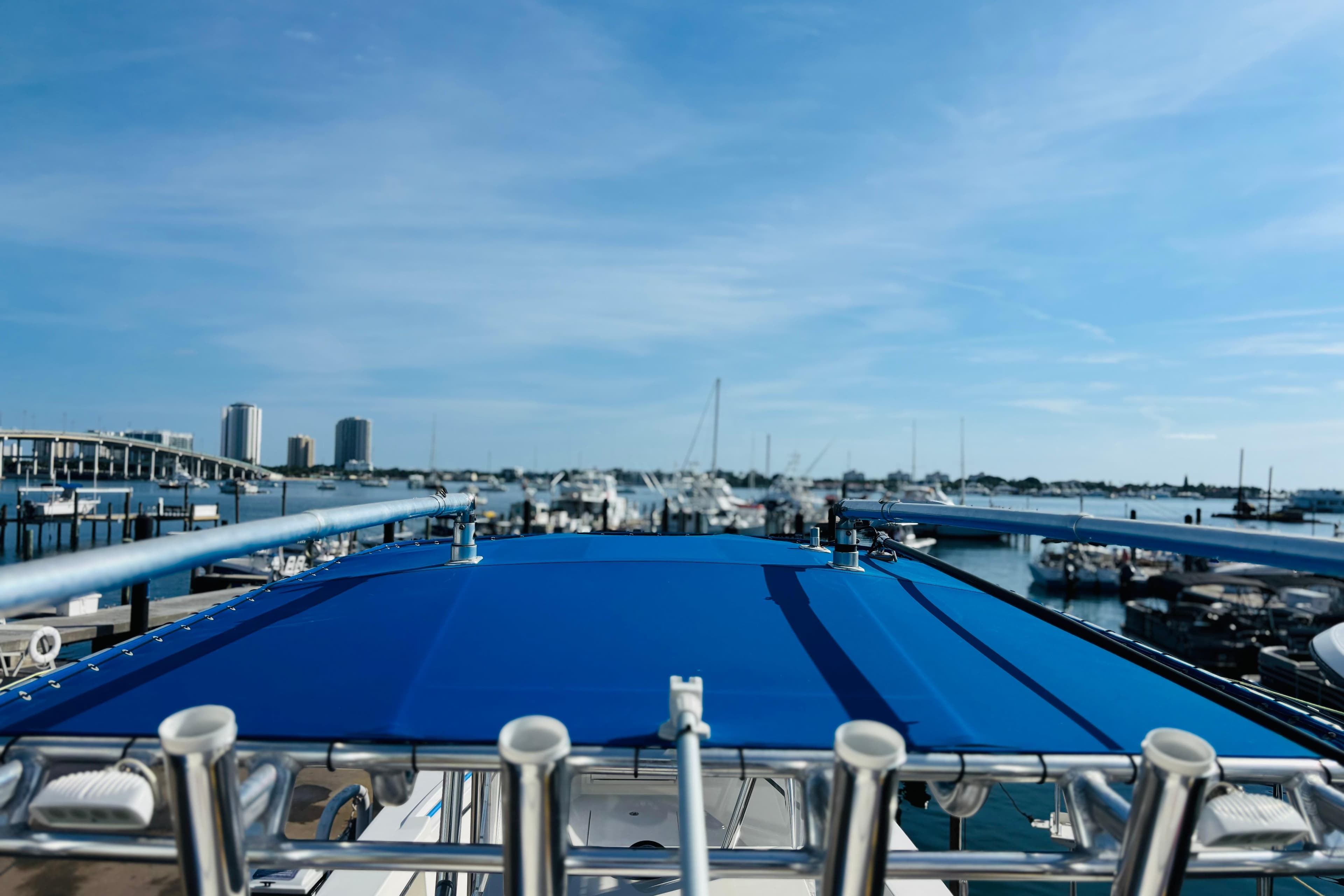 View from a 2016 Whitewater boat with blue canopy, overlooking a marina.