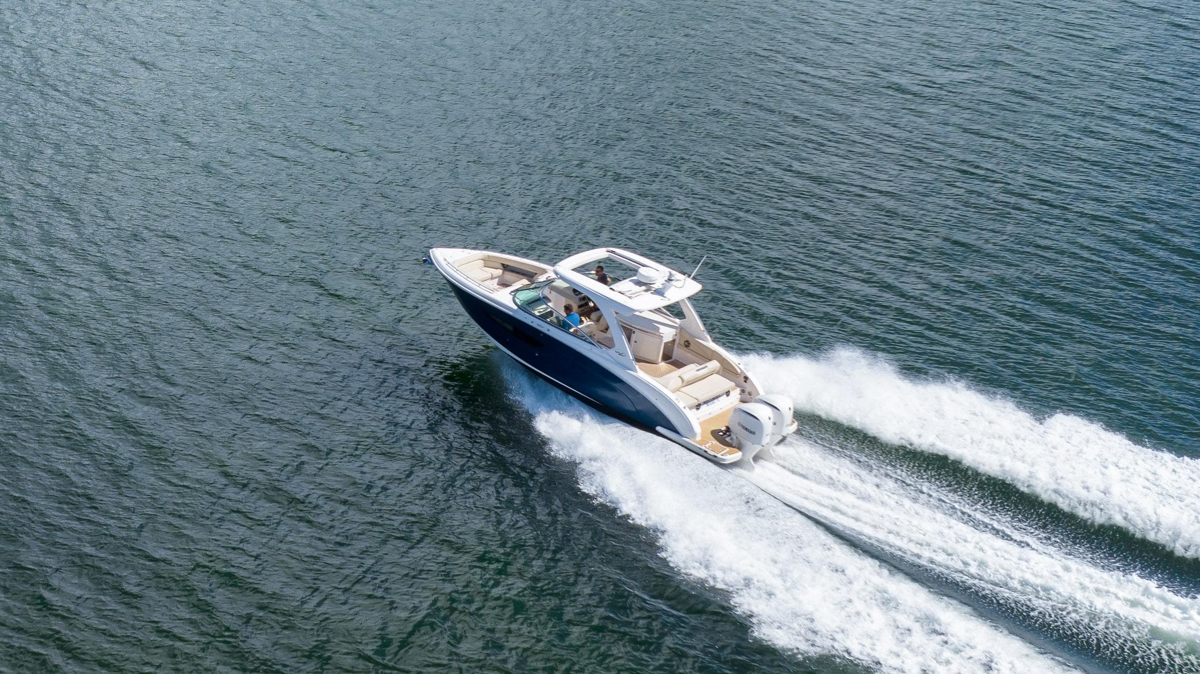 2019 Regal 33 OBX boat cruising on open water, creating a wake.