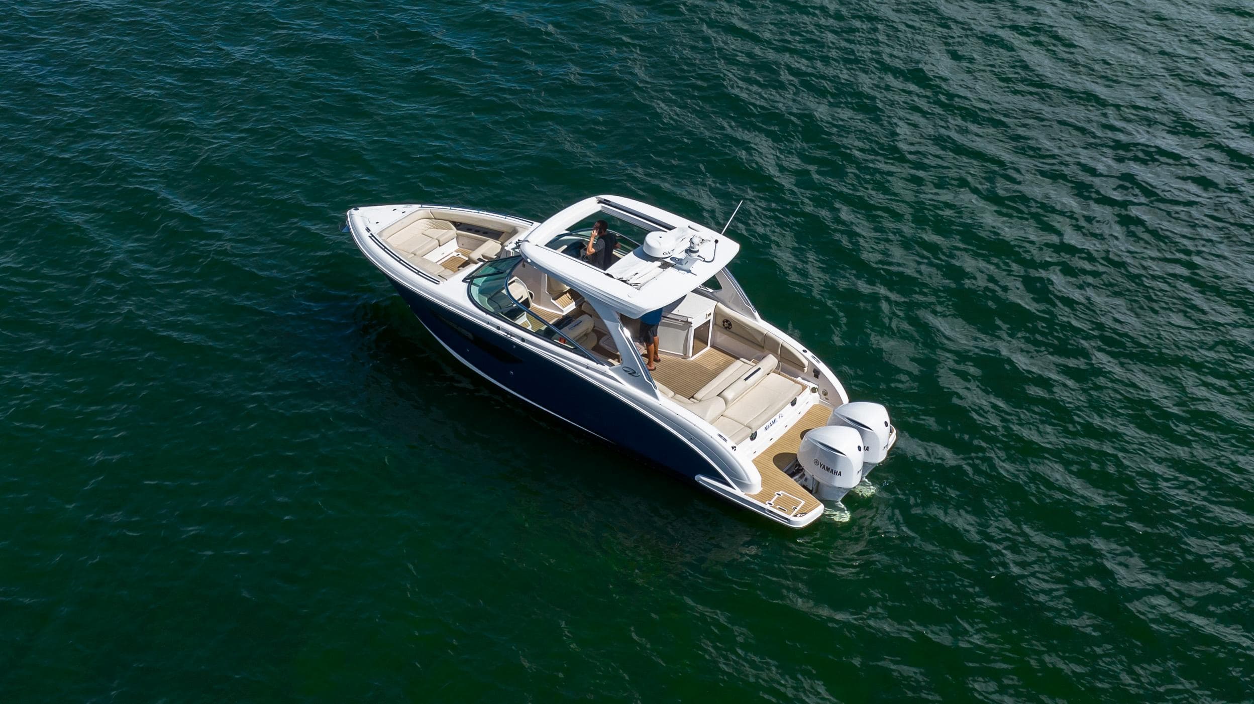 2019 Regal 33 OBX boat cruising on open water, aerial view.