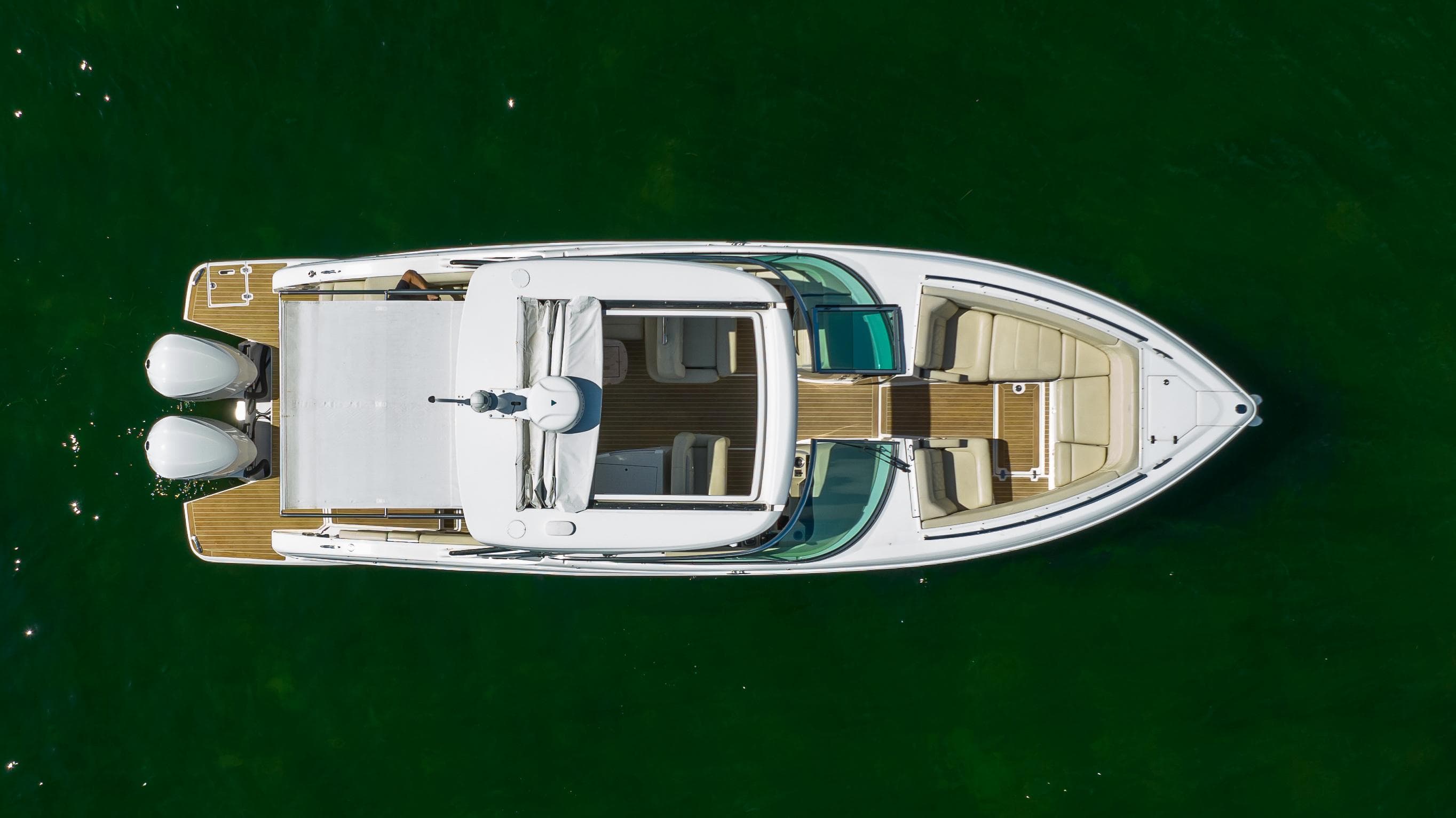 2019 Regal 33 OBX boat, aerial view, on green water.