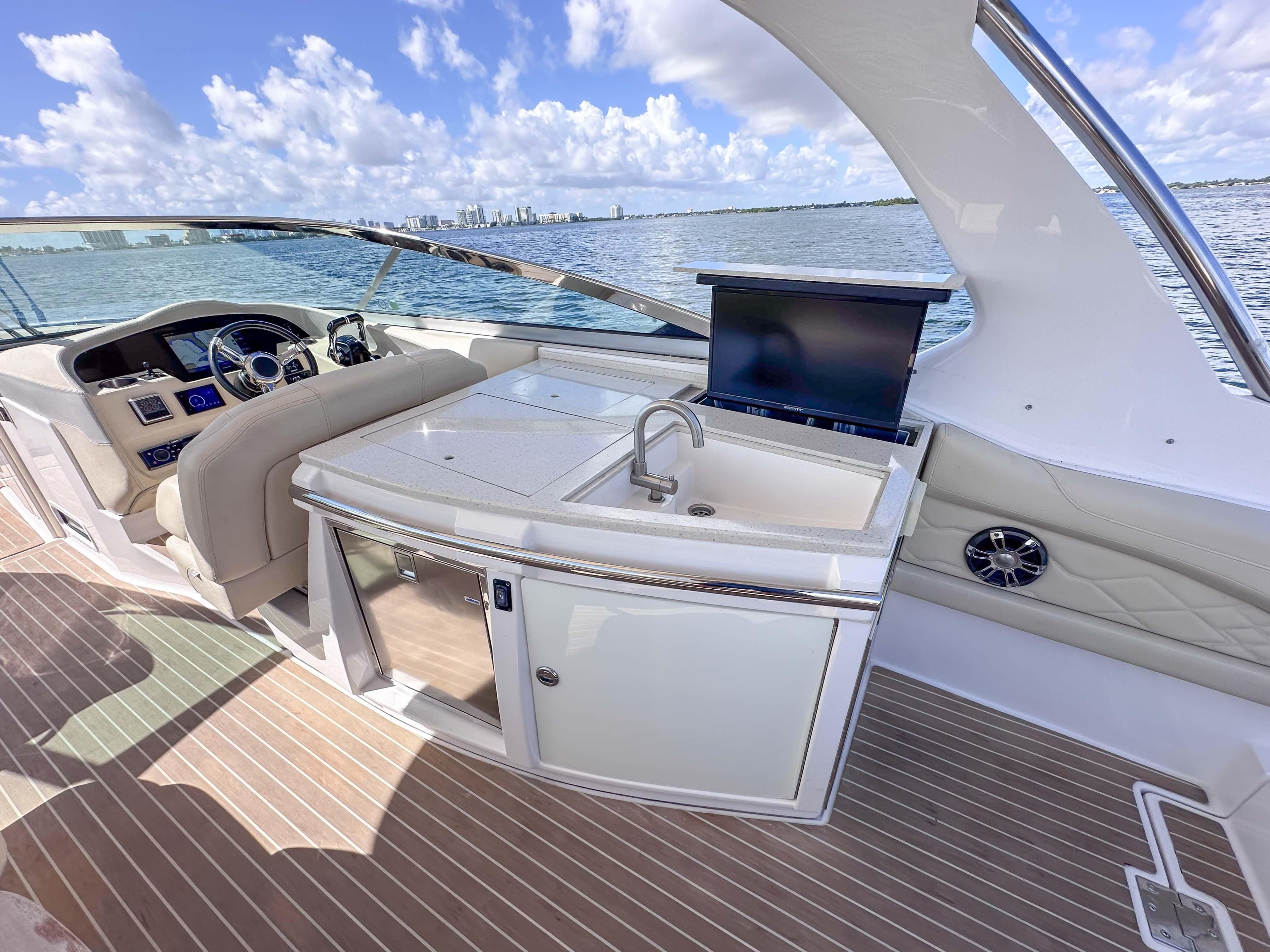 2019 Regal 33 OBX boat interior with helm, sink, and seating on a sunny day.