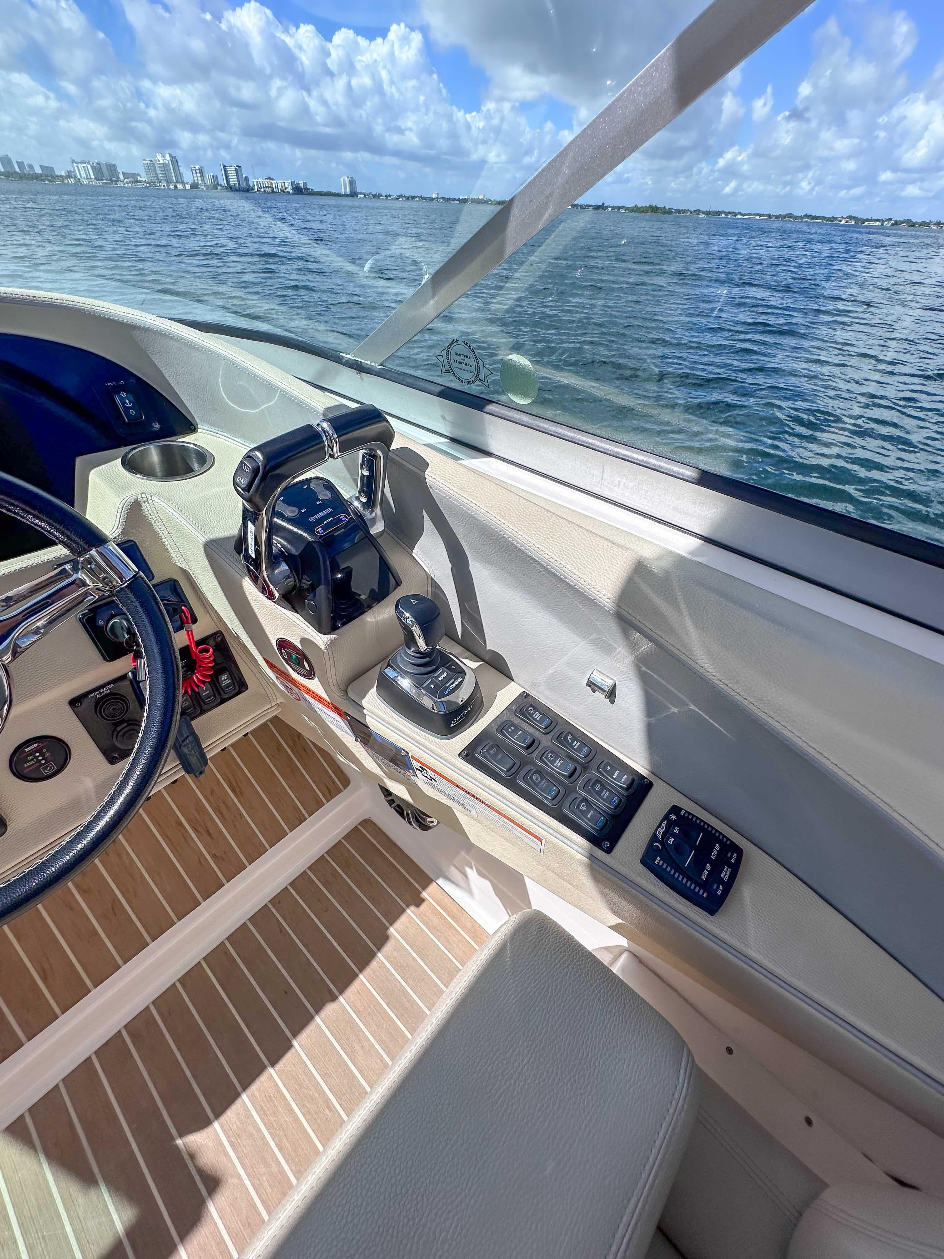 2019 Regal 33 OBX boat cockpit with controls, steering wheel, and ocean view.
