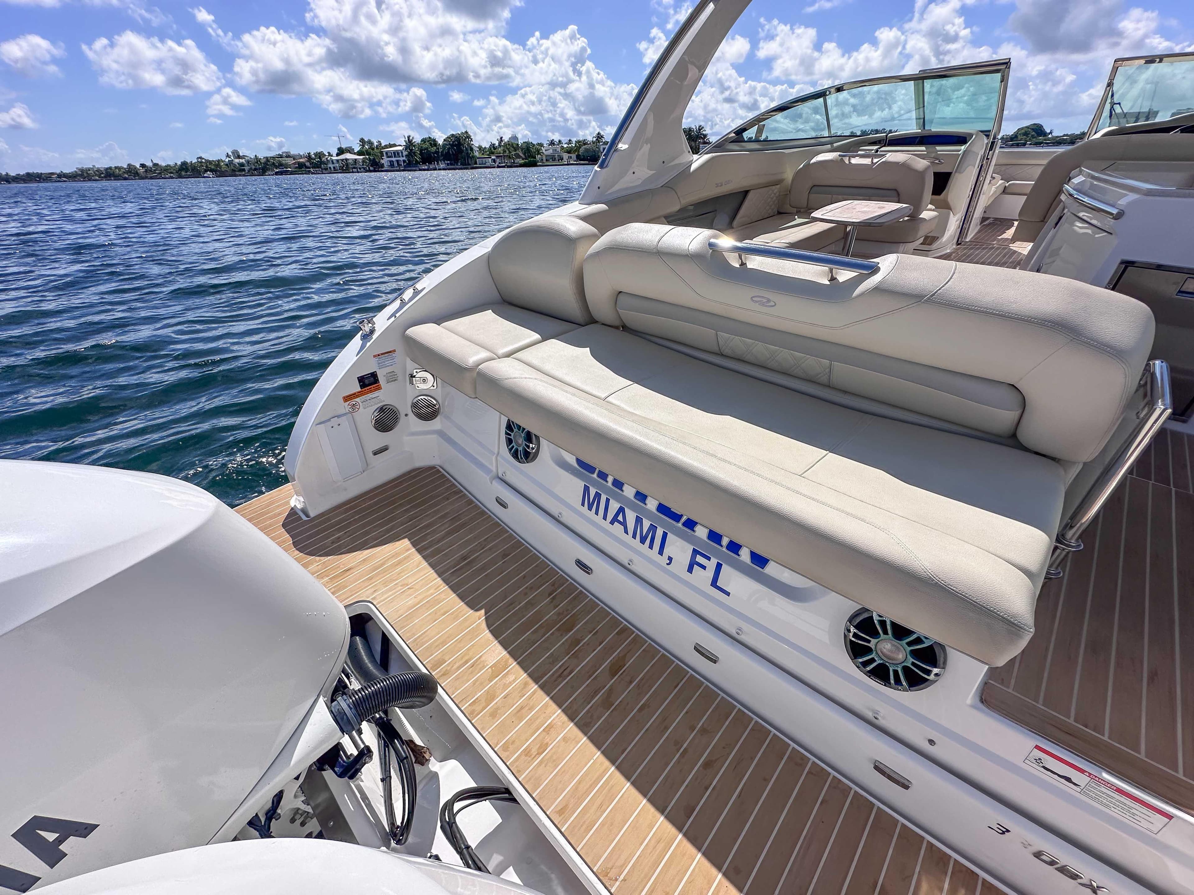 2019 Regal 33 OBX boat with beige seating, docked in Miami, FL, under a sunny sky.