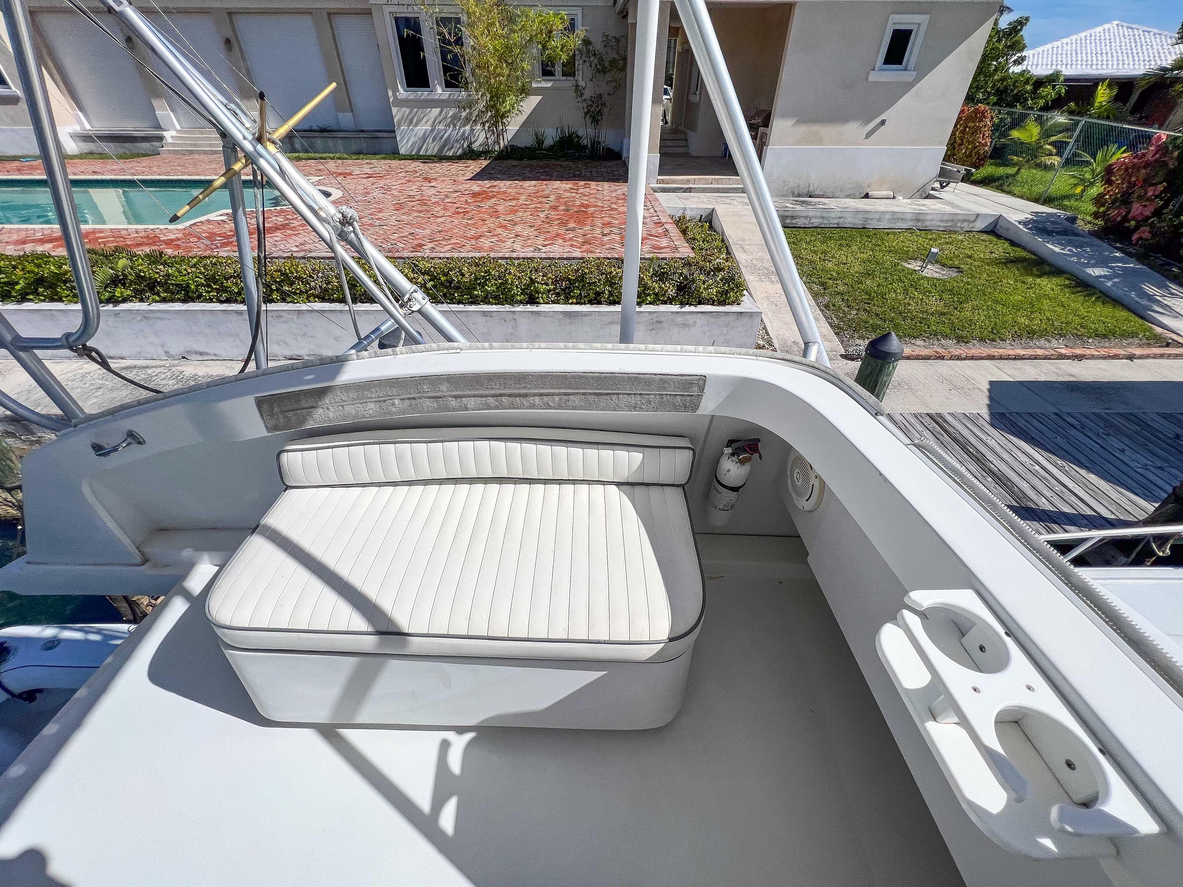 2000 Luhrs 400 Convertible boat seating area with white cushioned bench and cup holders.