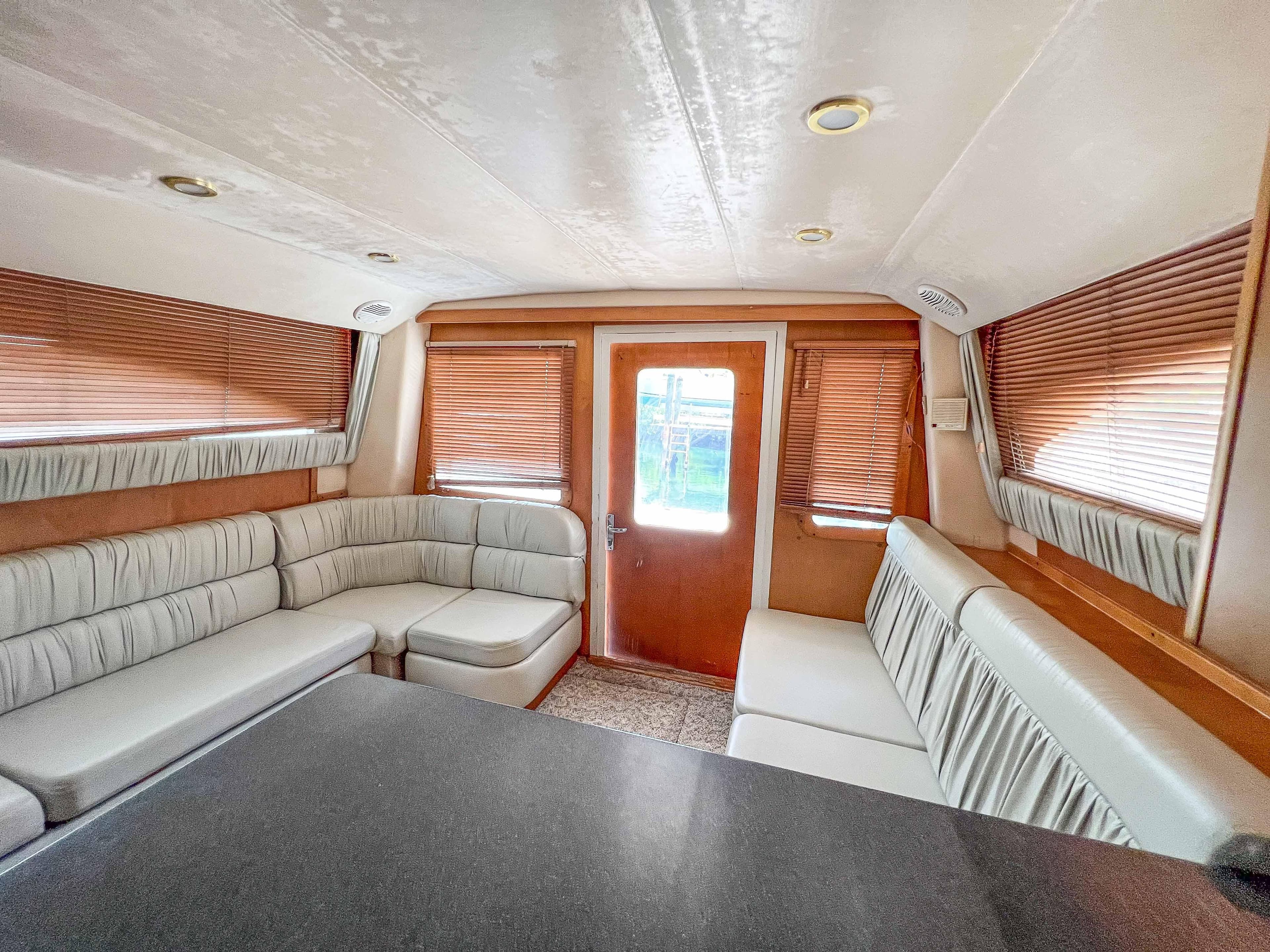 Interior of 2000 Luhrs 400 Convertible yacht with beige seating and wooden accents.