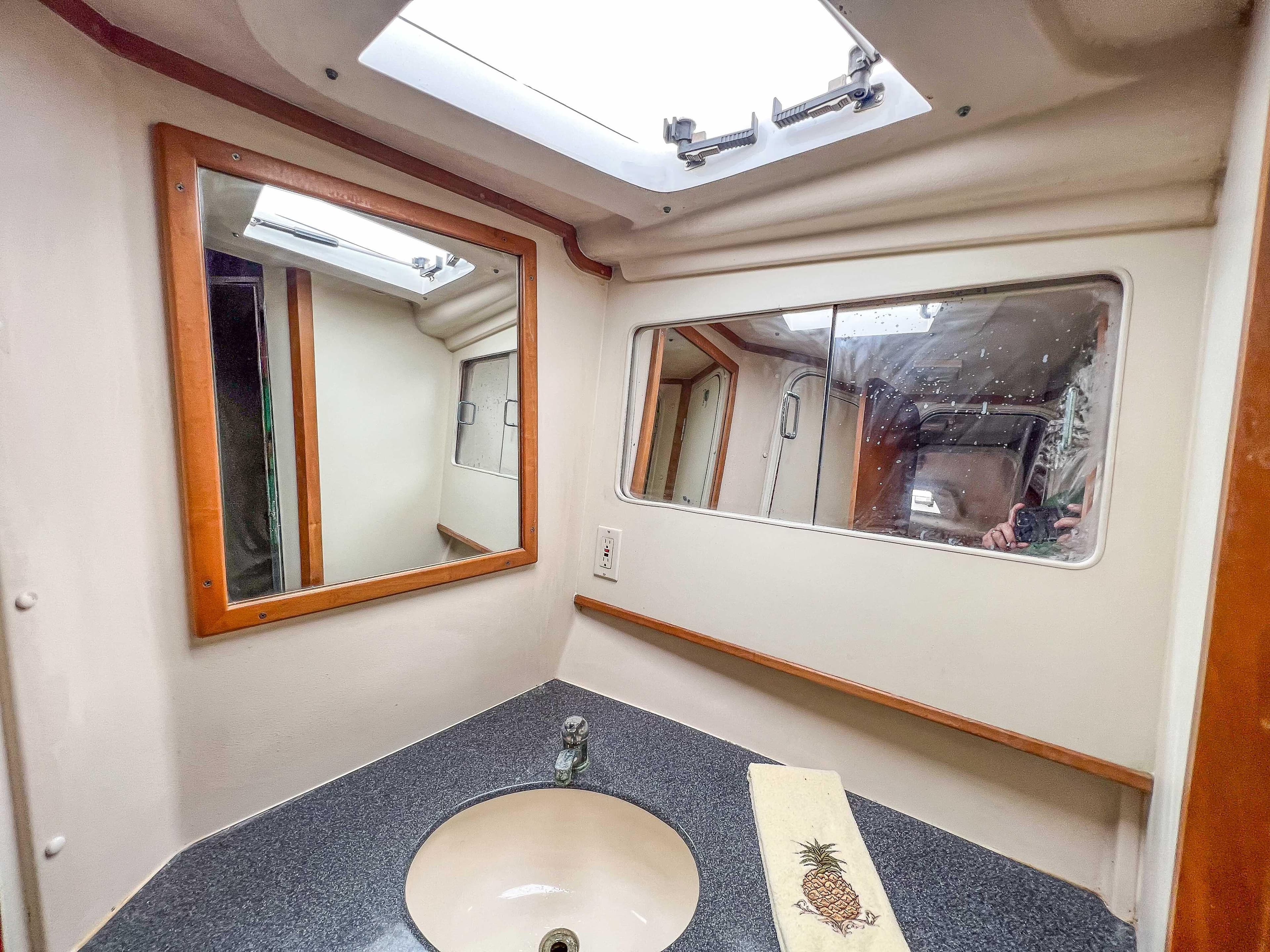 Bathroom vanity area in a 2000 Luhrs 400 Convertible boat with mirrors and sink.
