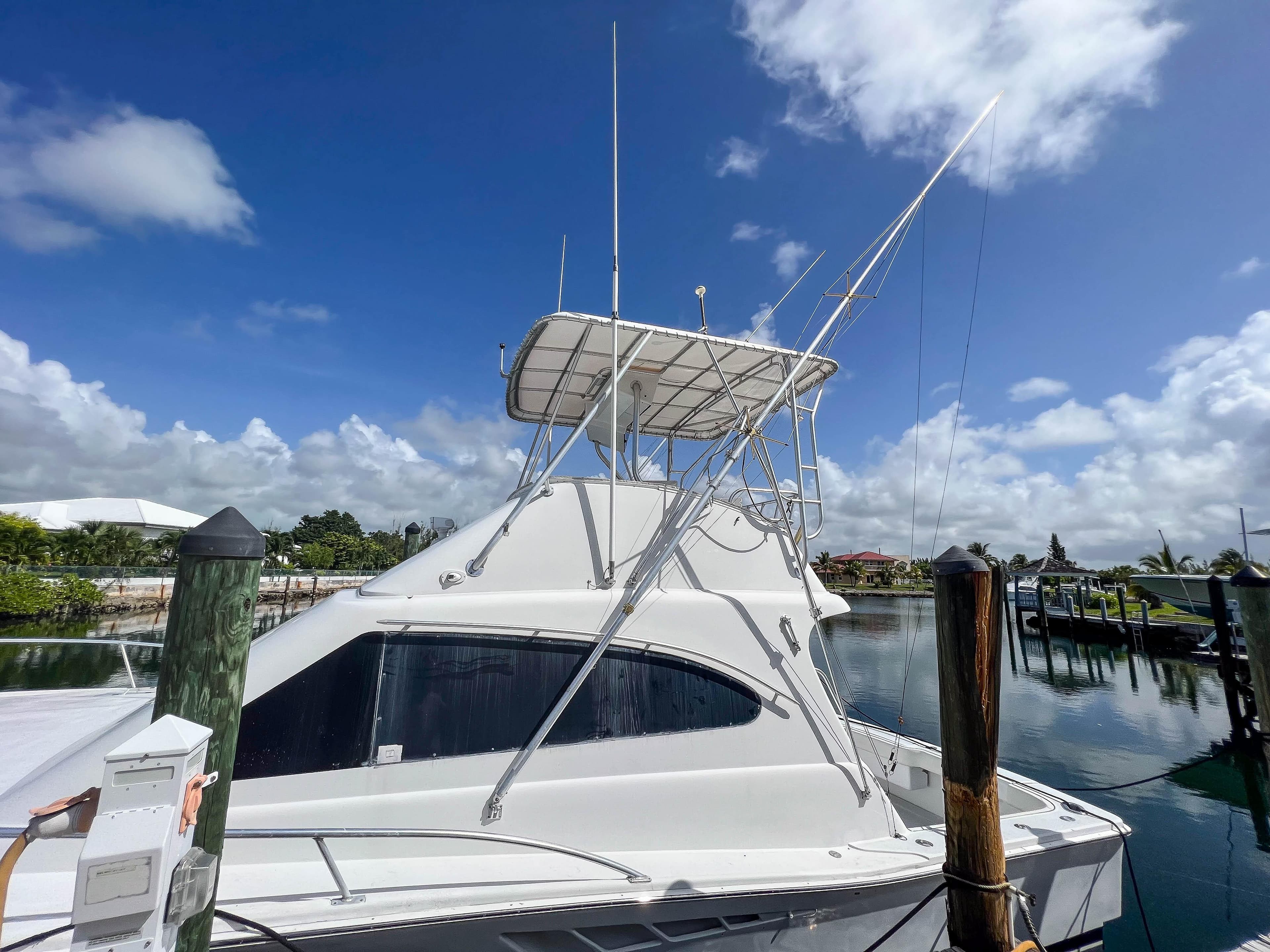 2000 Luhrs 400 Convertible boat docked at a marina under a clear blue sky.