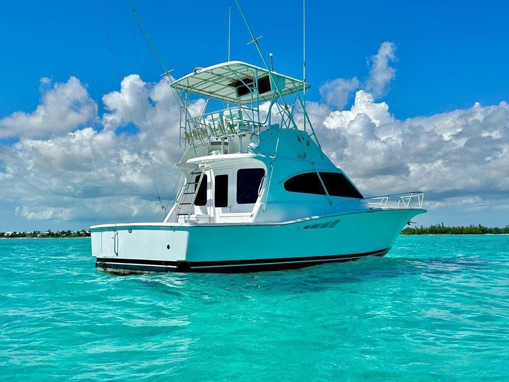 2000 Luhrs 400 Convertible yacht on clear turquoise water under a blue sky.