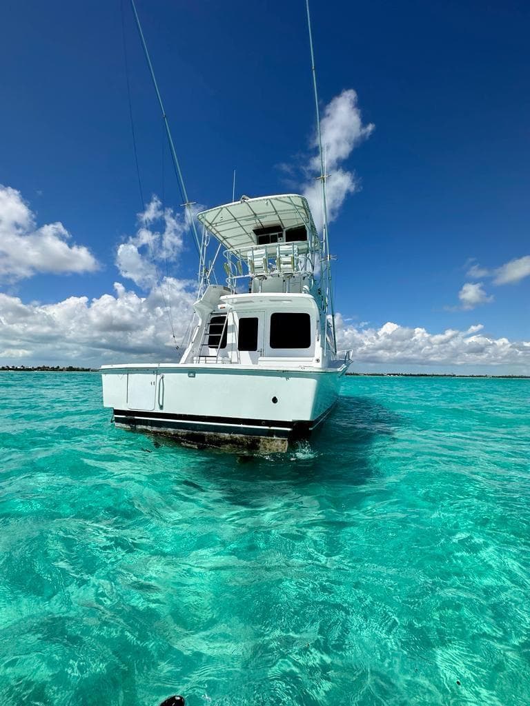 2000 Luhrs 400 Convertible boat on clear turquoise water under a blue sky.